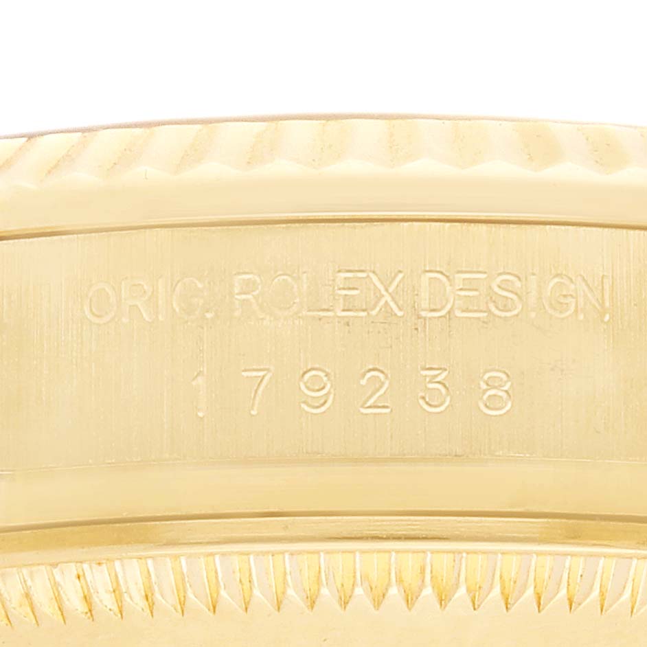 The image shows a close-up of the side of a Rolex President 179238 Women's Yellow Gold Champagne Dial model, highlighting the case with engraved design details.