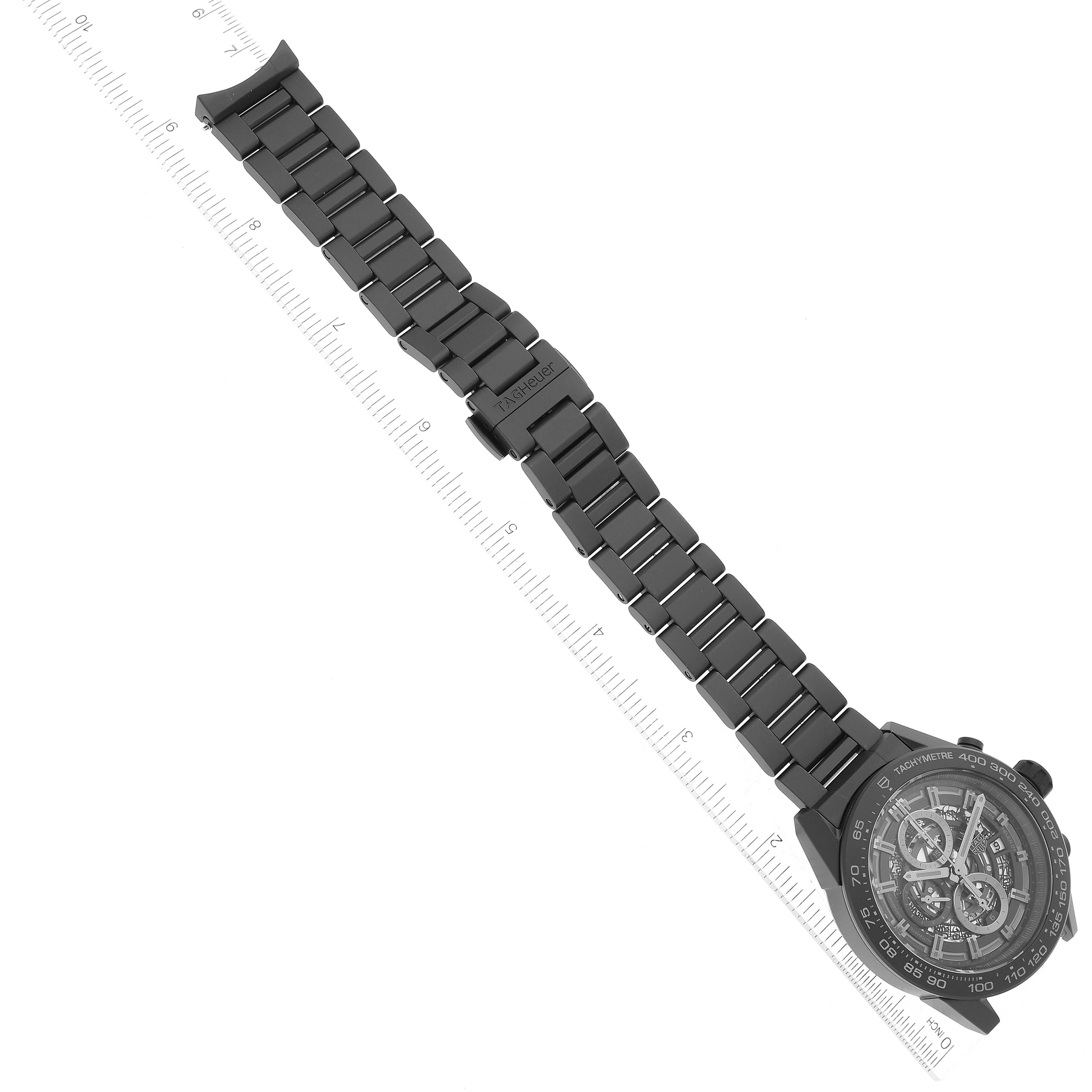 This image shows a Tag Heuer Carrera CAR2A91 Men's Ceramic Black Dial CAR2A91 Men's Ceramic Black Dial watch, angled to display its face and metal bracelet against a ruler background.