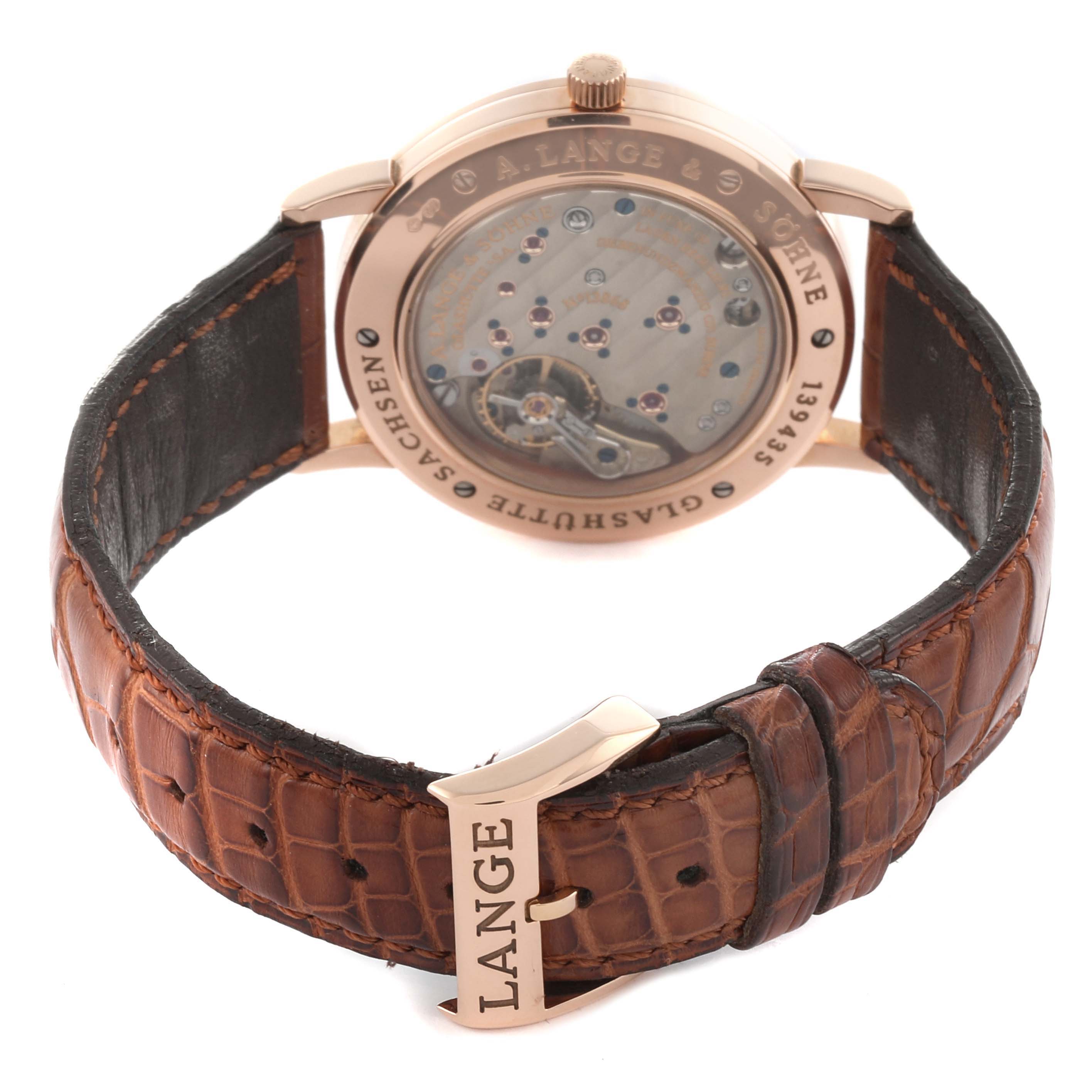 The A. Lange 
Sohne 1815 221.032 / LSLS2214AD Men
s Rose Gold Silver Dial watch is shown from the rear, displaying the movement and leather strap with a buckle.