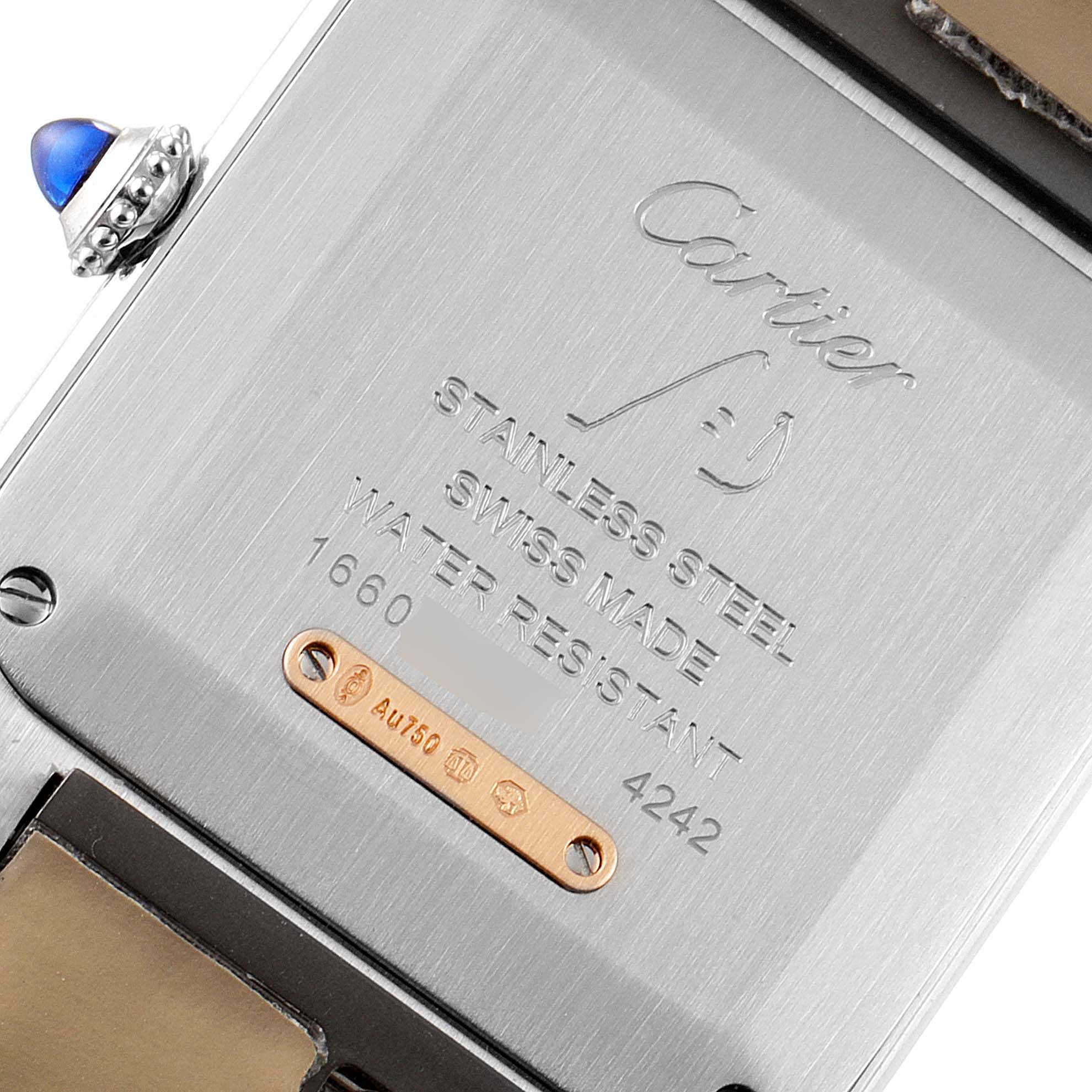 This image shows the back case of a Santos model by Cartier, including the crown and engravings.