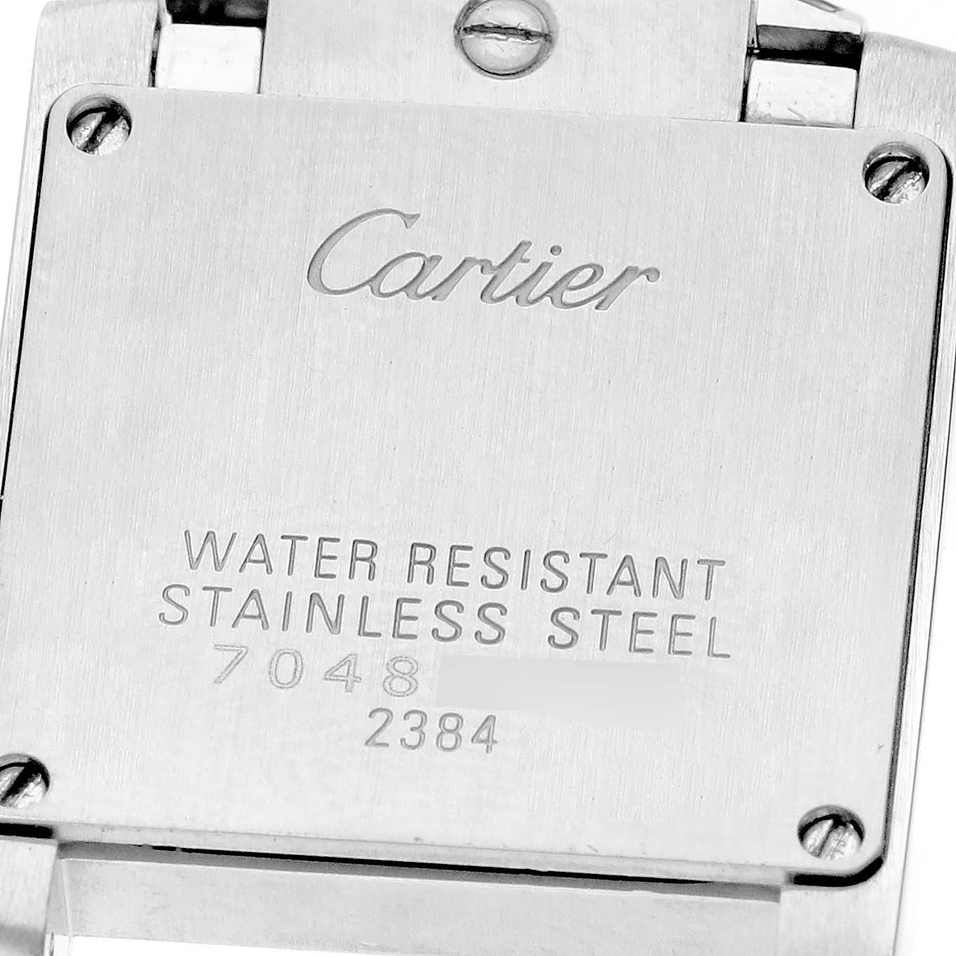 The image shows the stainless steel case back of a Cartier Tank Française, displaying branding and model-specific details.