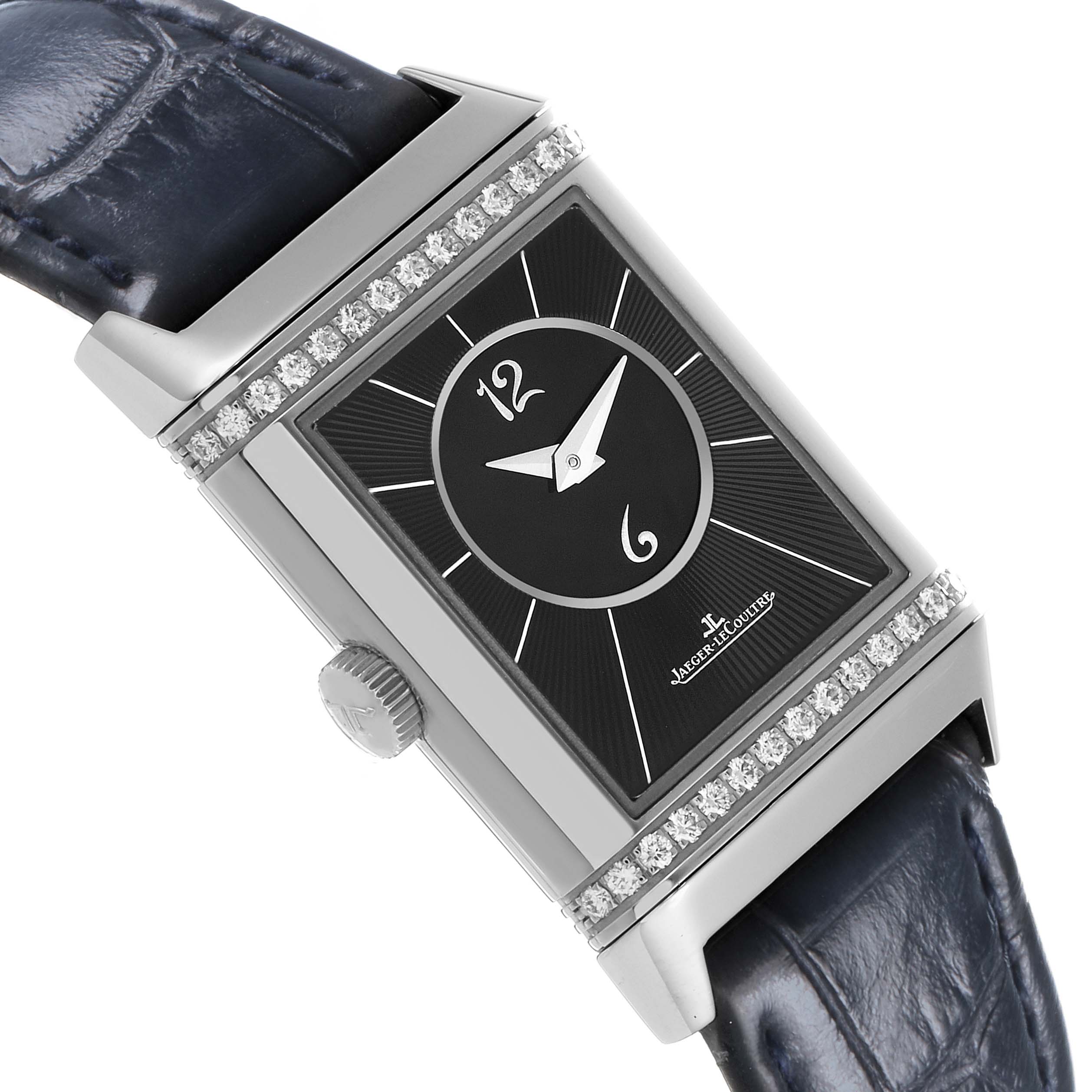 The Jaeger-LeCoultre Reverso watch is shown at an angle highlighting its face, diamond bezel, and side crown.
