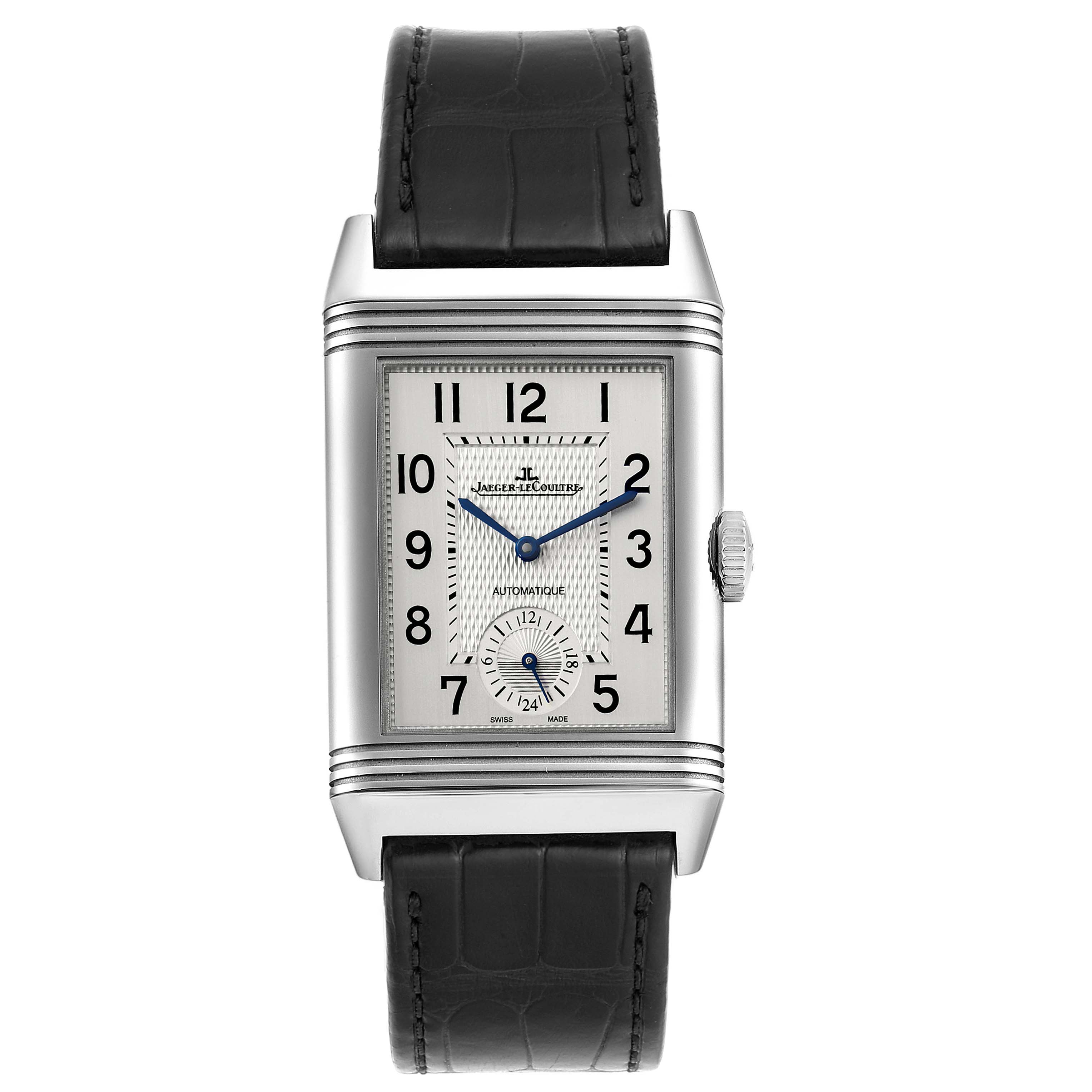 The Jaeger-LeCoultre Reverso watch is shown from a front angle, displaying its rectangular face, crown, and black strap.