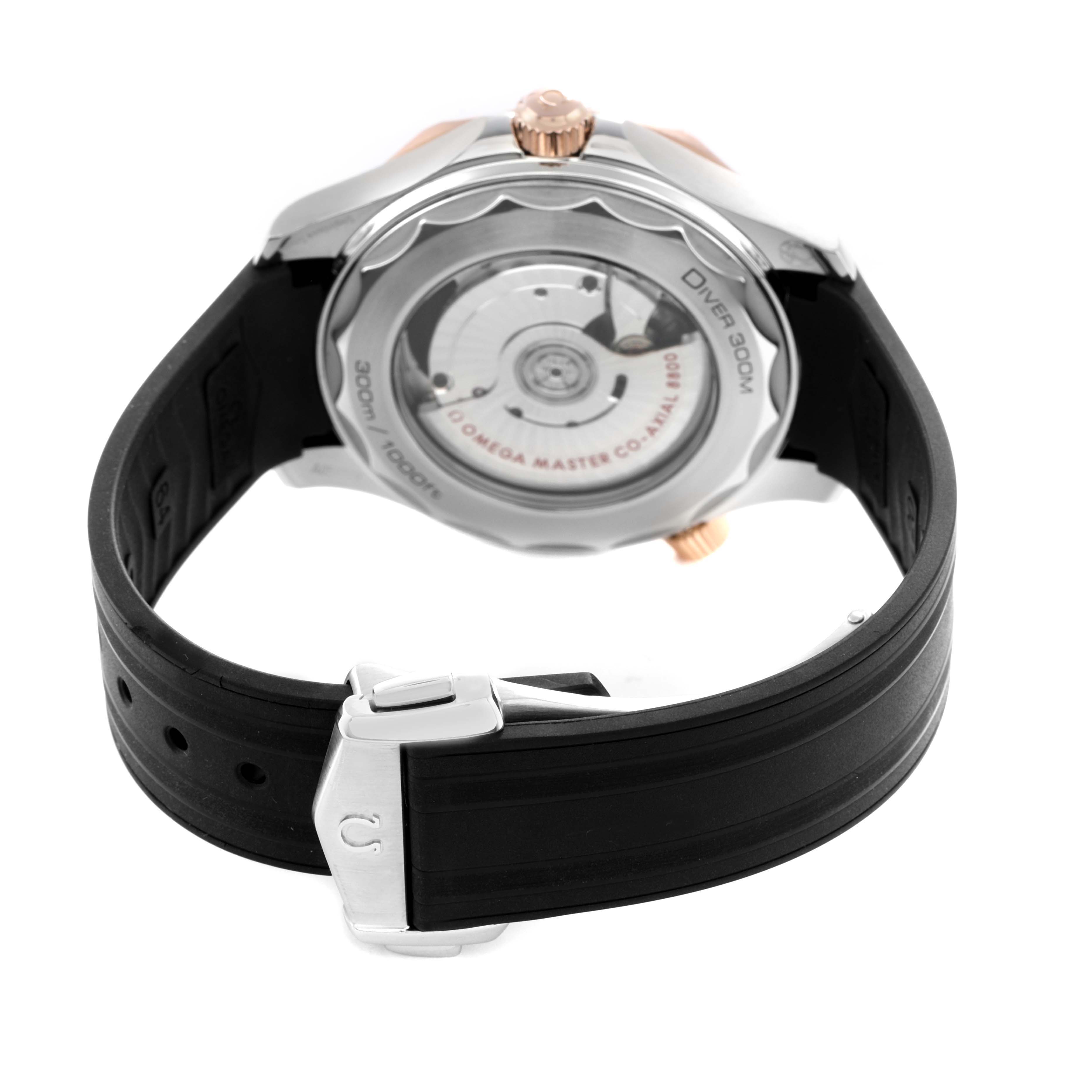 The image shows the back of an Omega Seamaster 210.22.42.20.01.002 Men's Steel and Gold (two tone) Black Dial watch, highlighting the case back and black rubber strap with a deployment clasp.