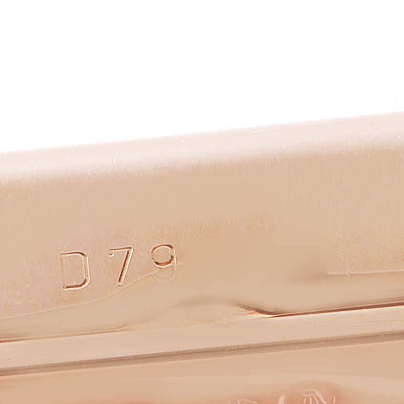 The image shows the edge of a Rolex Cellini 5442 Men's Rose Gold Black Dial 5442 Men's Rose Gold Black Dial watch case, highlighting the engraved serial number "D79."