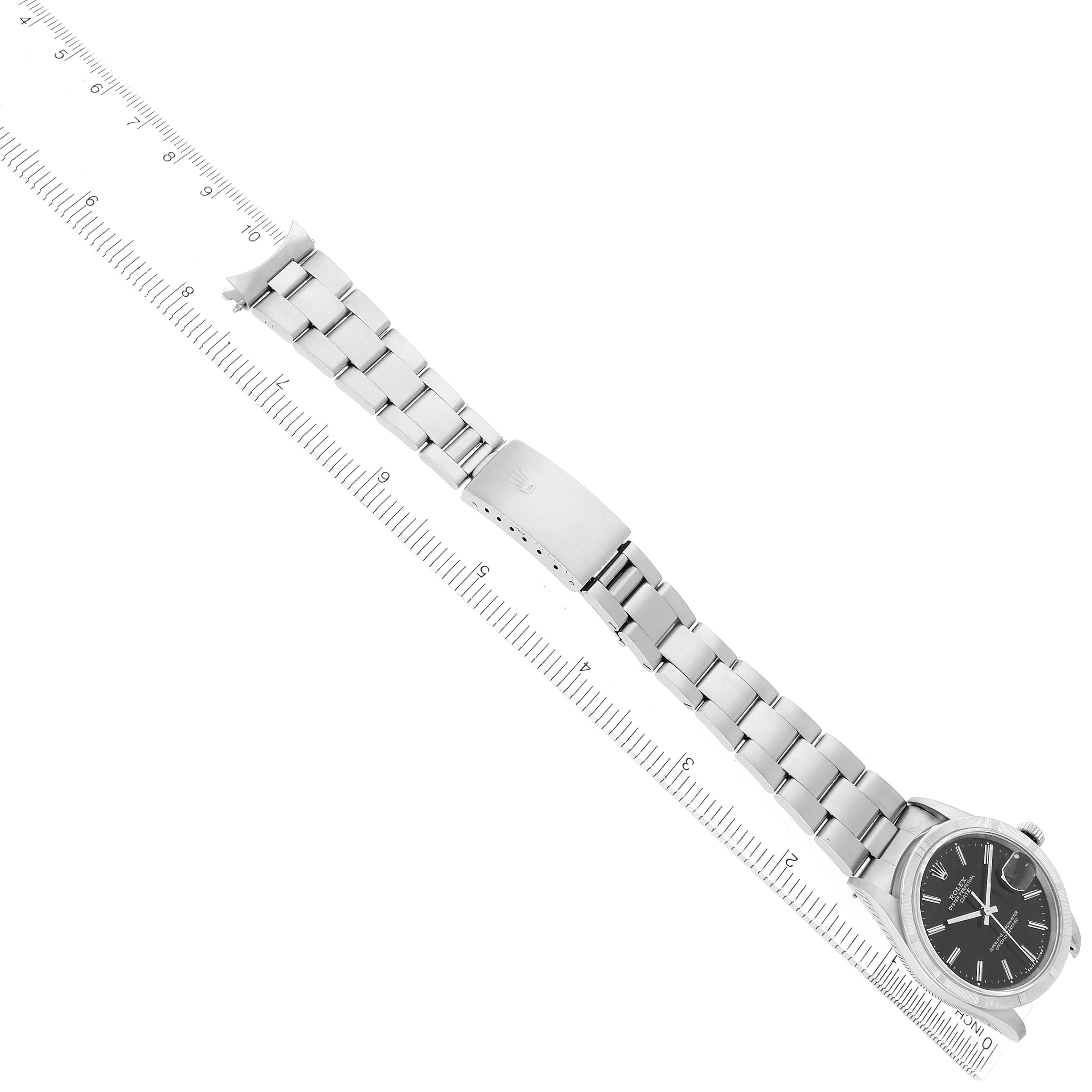 The Rolex Date 15210 Men's Stainless Steel Black Dial watch is displayed diagonally, showcasing its face, bracelet, and clasp alongside a measuring scale.