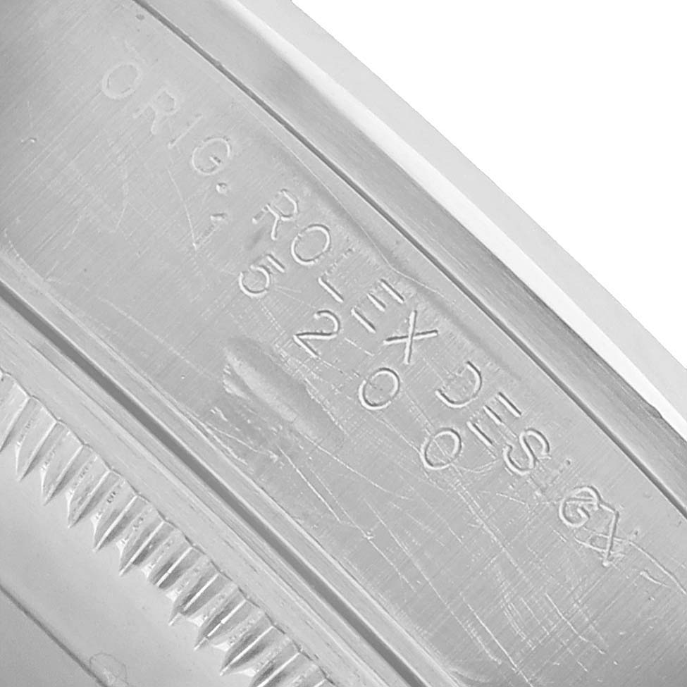 The image shows the engraved inner rim of a Rolex Date 15200 Men's Stainless Steel Pink Dial model watch, displaying the brand and model details.