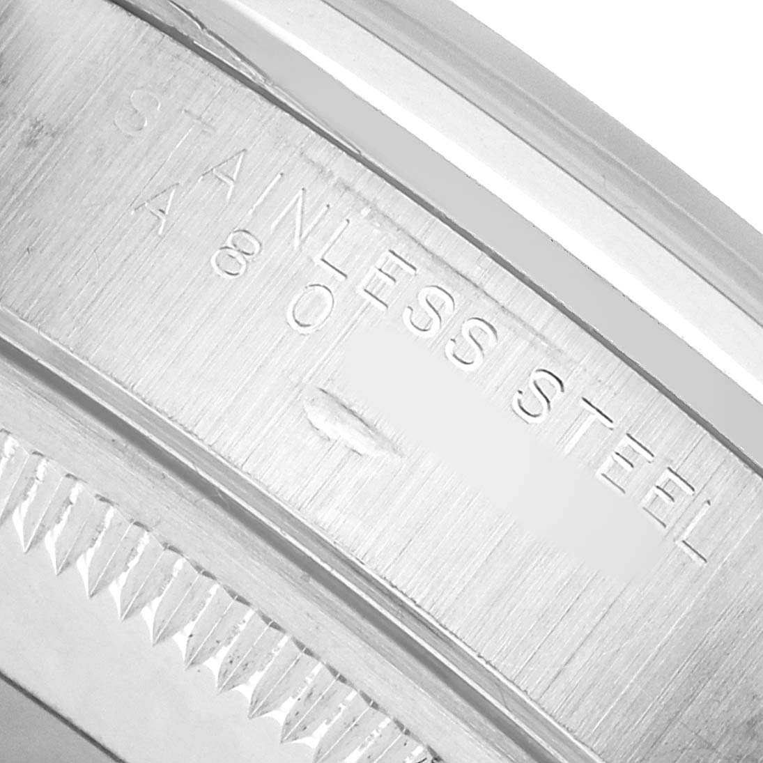 The image shows a close-up of the inner bezel or case edge of a Rolex Date 15200 Men's Stainless Steel White Dial, featuring "STAINLESS STEEL" engraving.