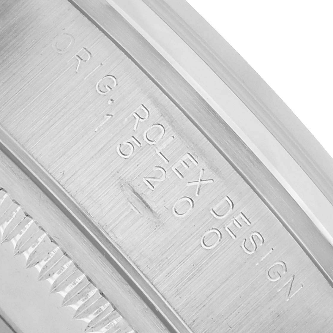 The image shows a close-up of the engraved inner bezel detail on a Rolex Date 15200 Men's Stainless Steel White Dial model.