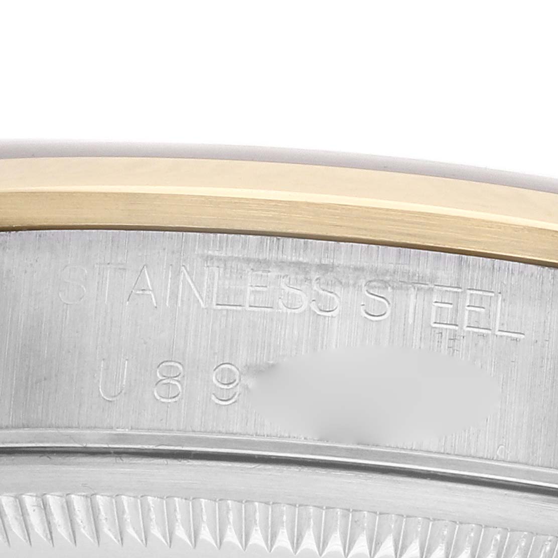 The image shows the side view of the Rolex Date 15203 Men's Steel and Gold (two tone) Grey Dial model's stainless steel case with inscription details.