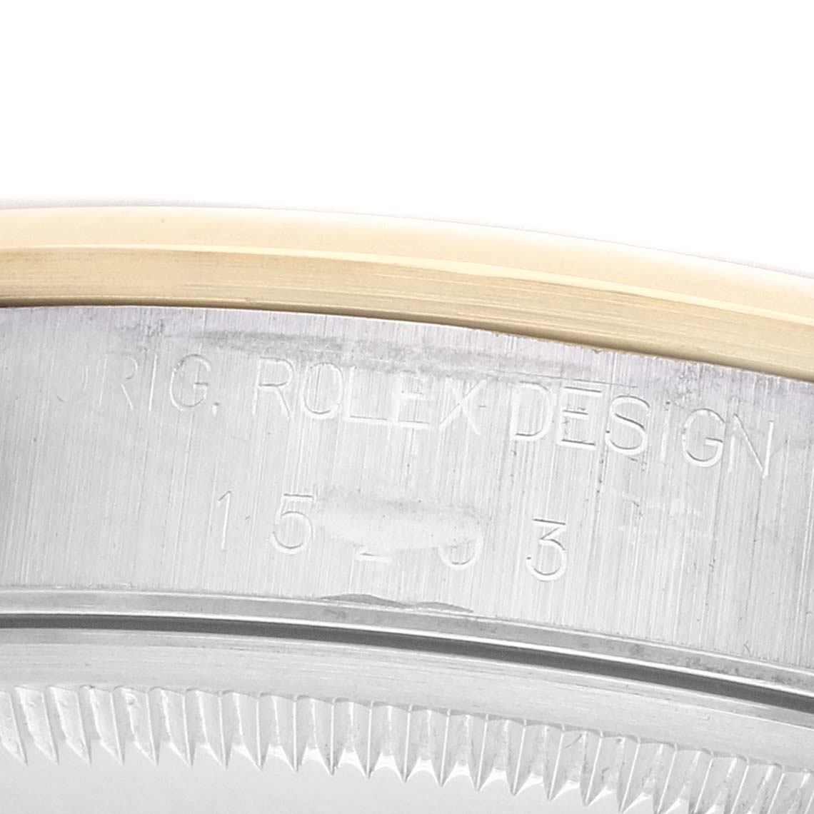 The image shows the side view of a Rolex Date 15203 Men's Steel and Gold (two tone) Grey Dial model, highlighting the engraved case edge.