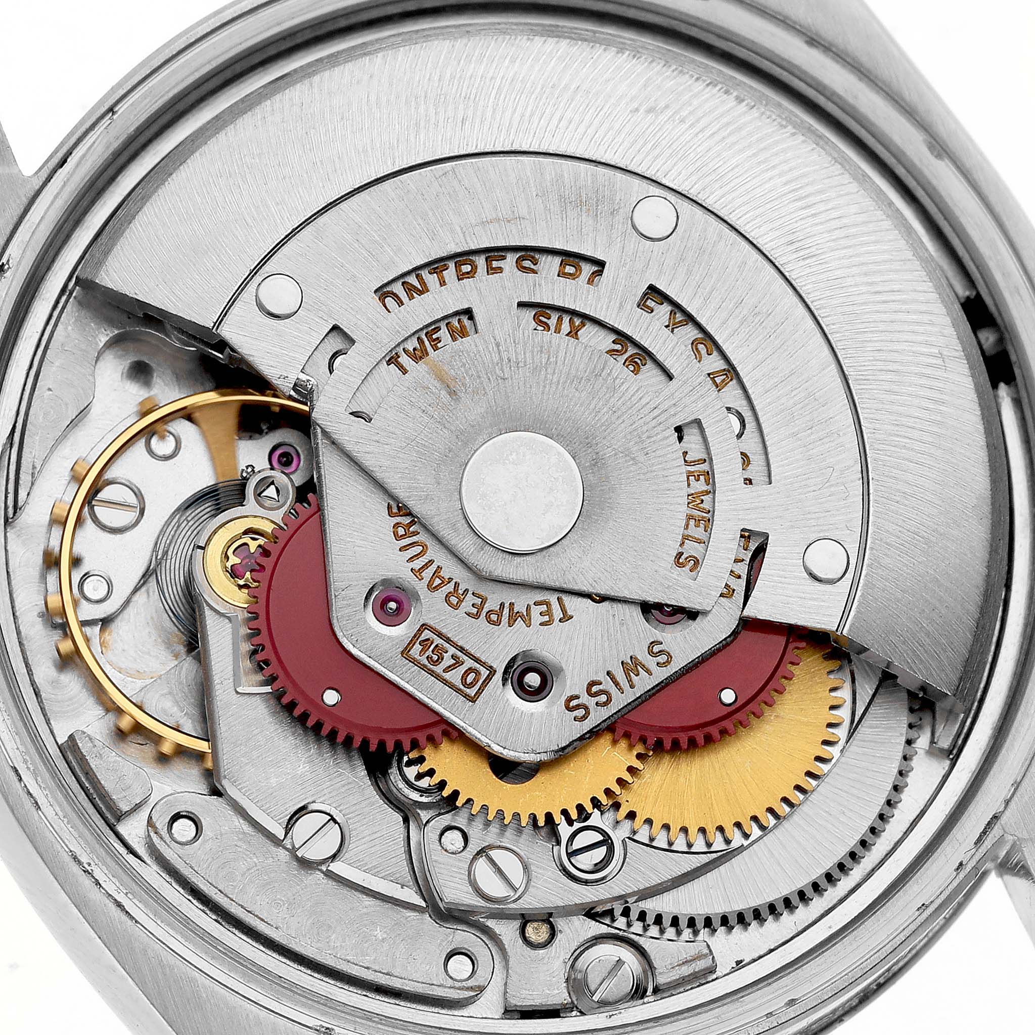 The image shows the inner mechanism of a Rolex Date 66579 Men's Stainless Steel White Dial 66579 Men's Stainless Steel White Dial watch, highlighting gears and movement components from a top-down angle.