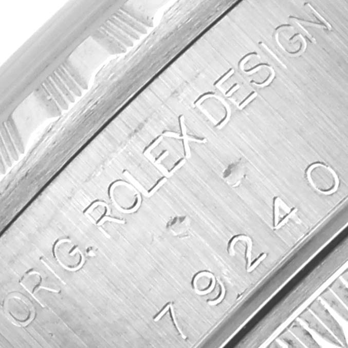 The image shows a close-up of the side of a Rolex Date 79240 Women
s Stainless Steel White Dial 79240 Women
s Stainless Steel White Dial model, featuring engraved text and the case design details.