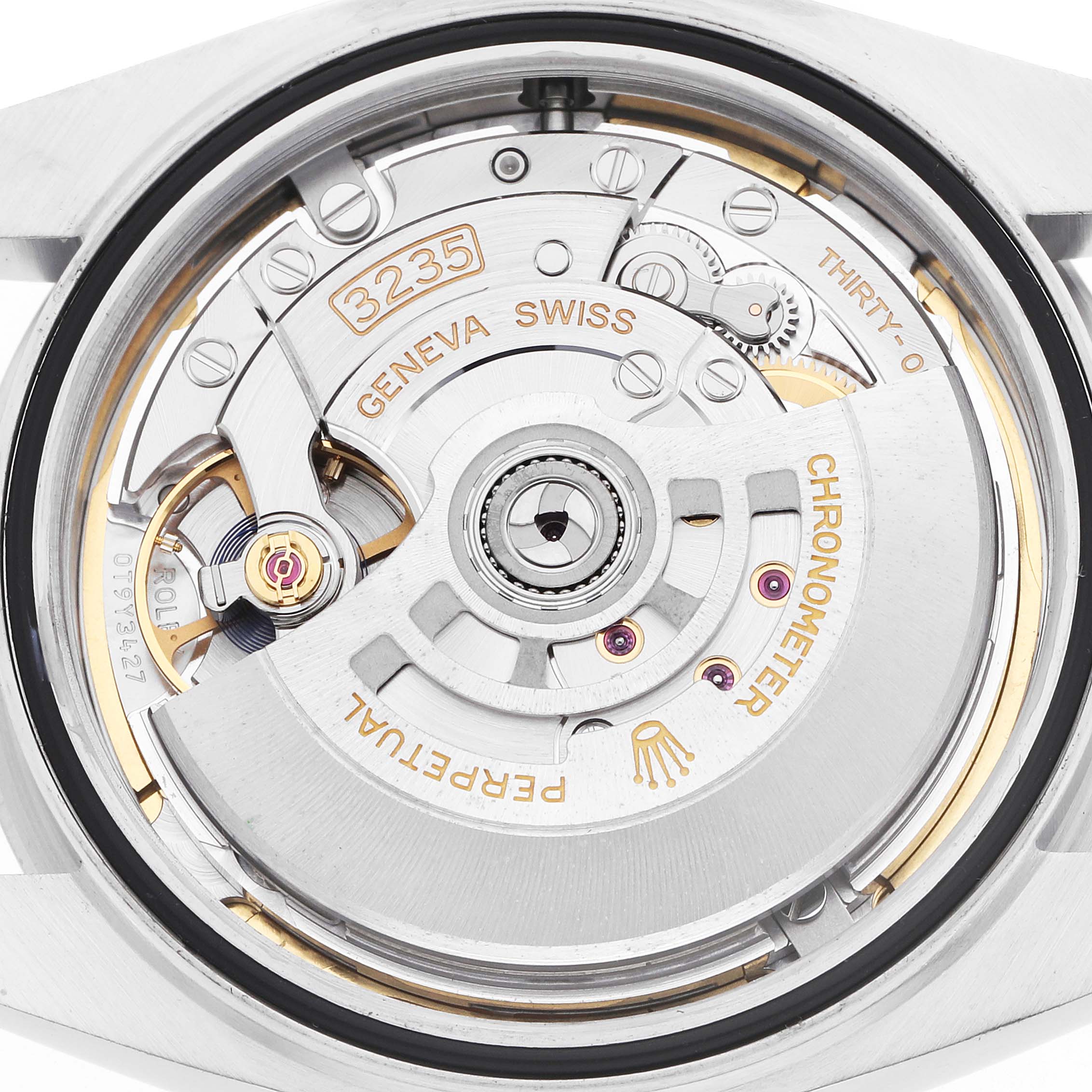The image shows a close-up of the Rolex Datejust 41 126300 Men's Steel and Gold (two tone) Grey Dial's movement mechanism, highlighting gears and engravings.