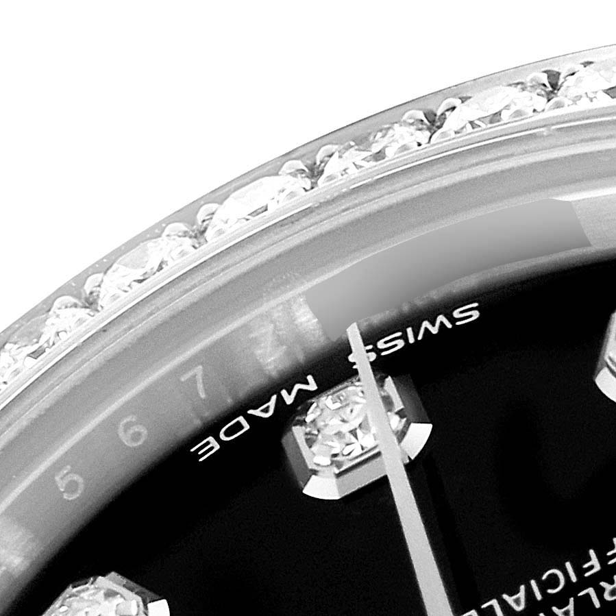 This close-up image of a Rolex Mid-Size 178384 Women
s Stainless Steel Black Dial 178384 Women
s Stainless Steel Black Dial watch shows the bezel with diamonds, part of the dial, and part of the second-hand.