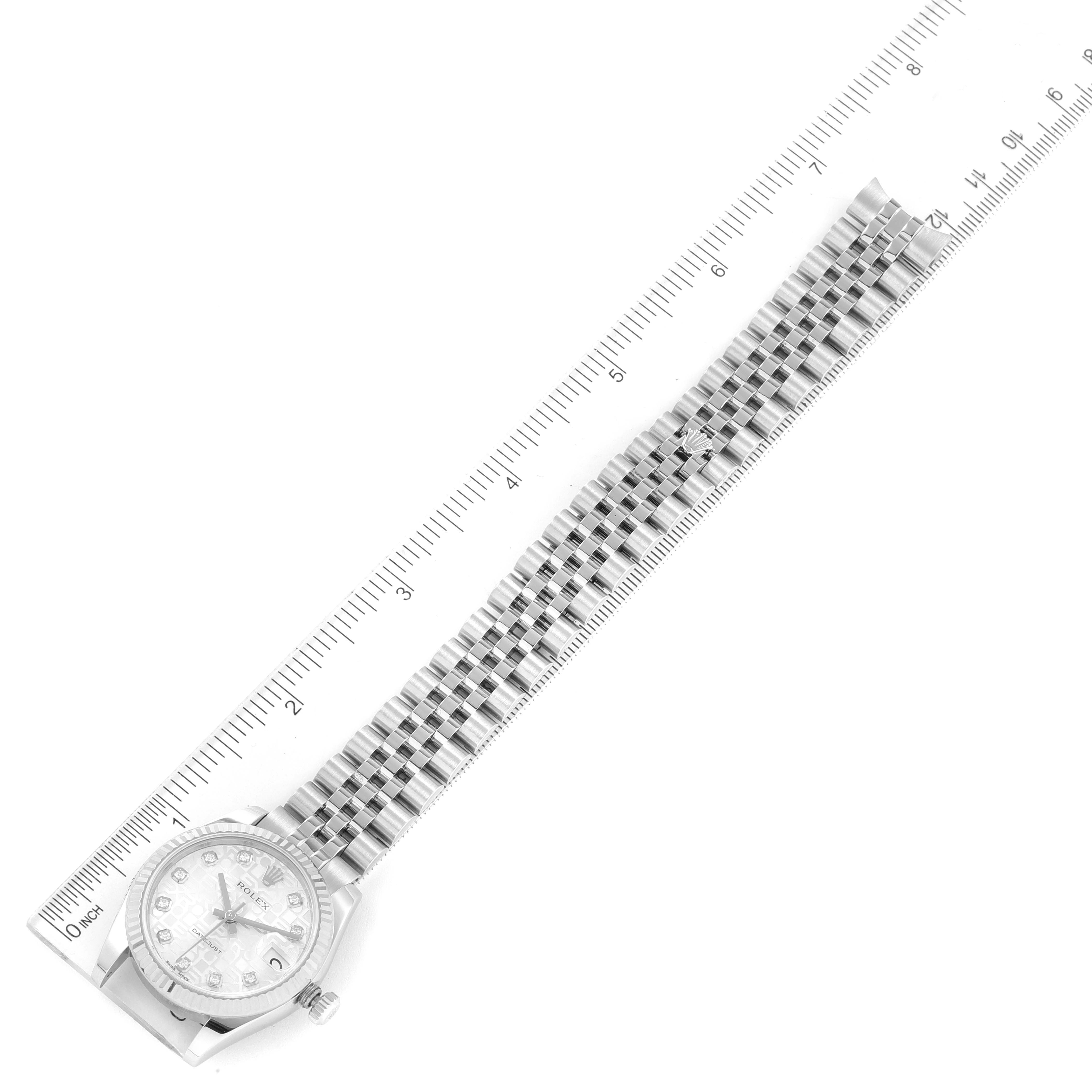 The image shows a top-down view of a Mid-Size Rolex watch with its entire bracelet and part of the dial visible, placed alongside a ruler.