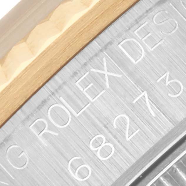 The image shows a close-up of a Rolex Mid-Size 68273 Women's Steel and Gold (two tone) Red Dial 68273 Women's Steel and Gold (two tone) Red Dial model's engraved case edge with partial serial number and branding.