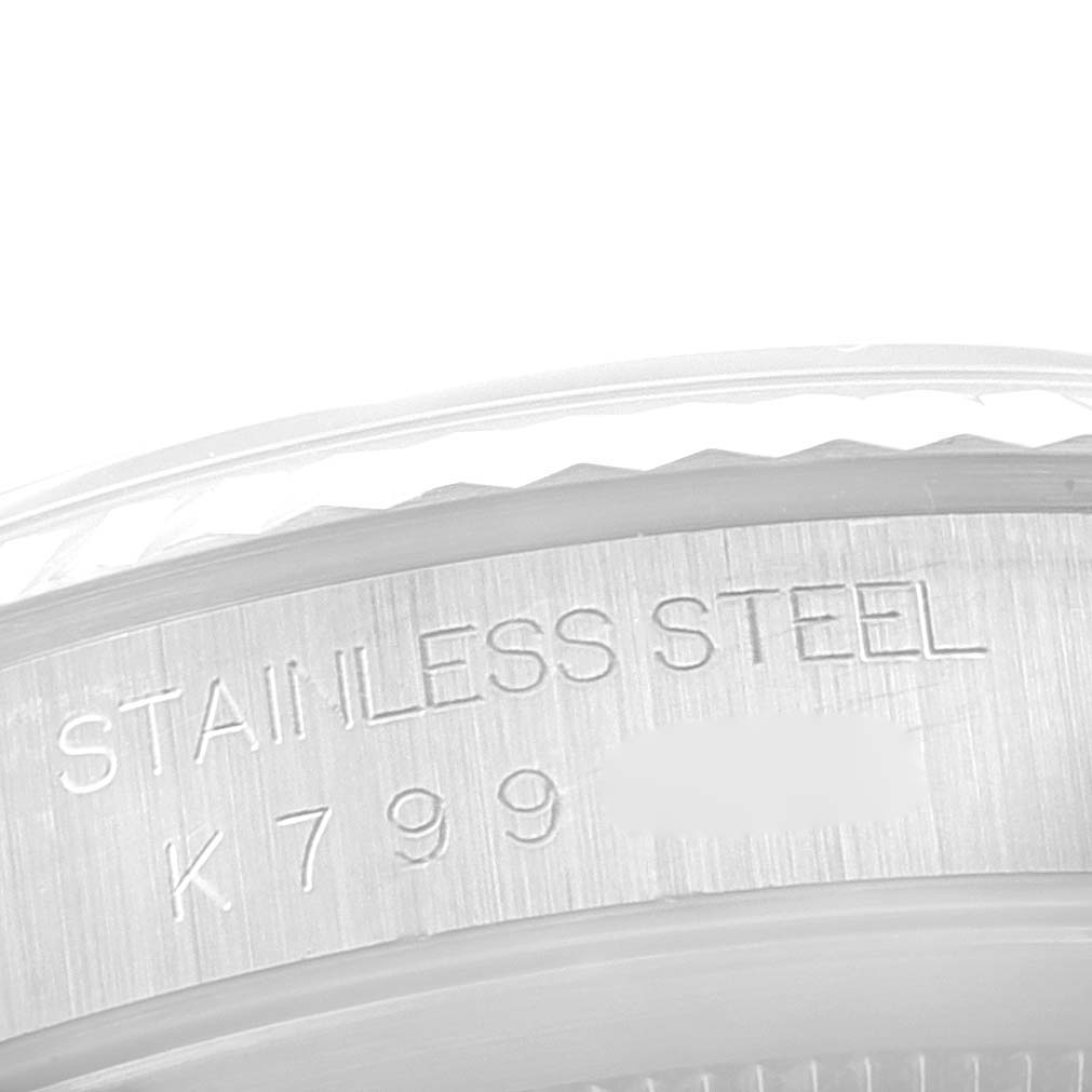 The image shows a close-up of the case back edge of a Rolex Datejust 16234 Men's Stainless Steel White Dial 16234 Men's Stainless Steel White Dial, displaying its stainless steel marking and part of the serial number.