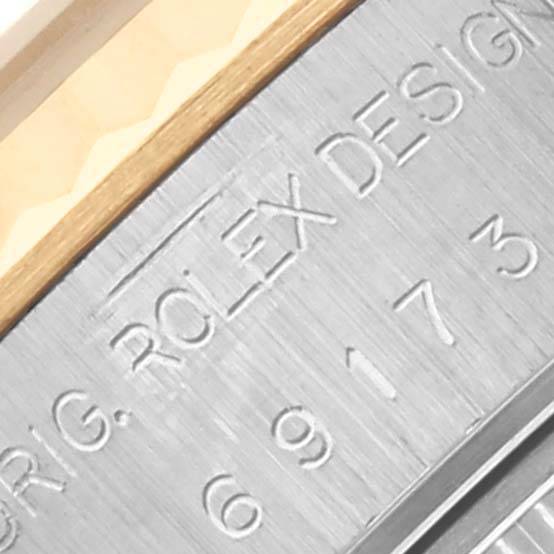 The image shows a close-up of the engravings on the side of a Rolex Datejust 69173 Women's Steel and Gold (two tone) Champagne Dial 69173 Women's Steel and Gold (two tone) Champagne Dial watch.