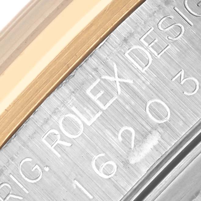 The image shows a close-up of the Rolex Datejust 16203 Men's Steel and Gold (two tone) Mother of Pearl Dial 16203 Men's Steel and Gold (two tone) Mother of Pearl Dial case edge with engraved text and part of the bezel.