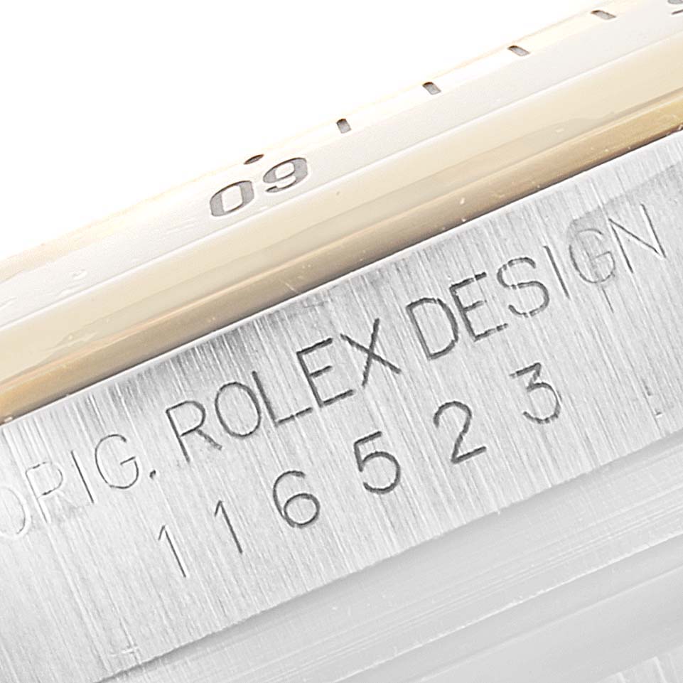 The image shows a close-up of the bezel and an engraved case side of a Rolex Daytona 116523 Men's Steel and Gold (two tone) Mother of Pearl Dial 116523 Men's Steel and Gold (two tone) Mother of Pearl Dial watch.