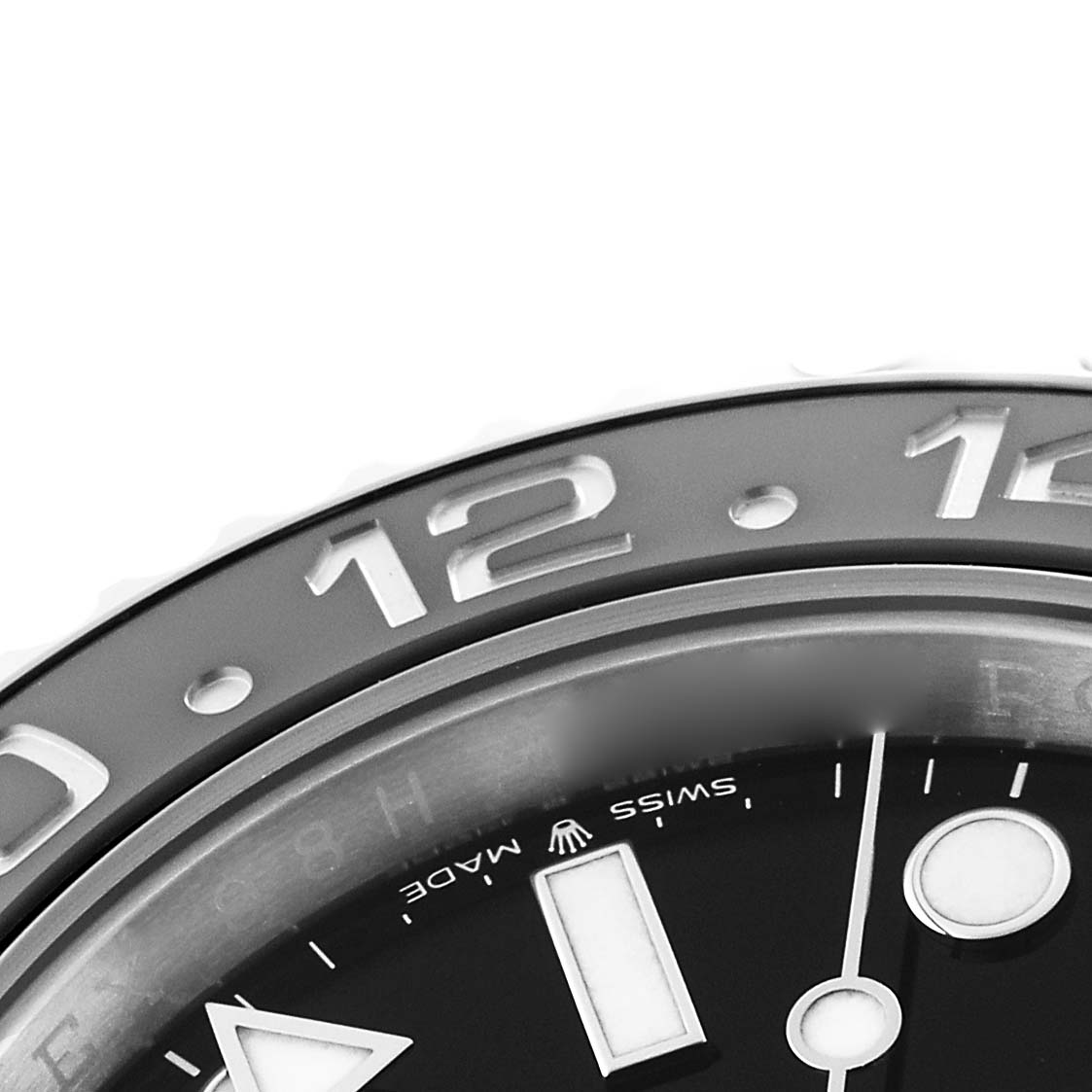 This close-up shows the bezel and part of the dial of a Rolex GMT-Master 126710GRNR Men's Stainless Steel Black Dial, highlighting the 12 numeral and Swiss Made text.