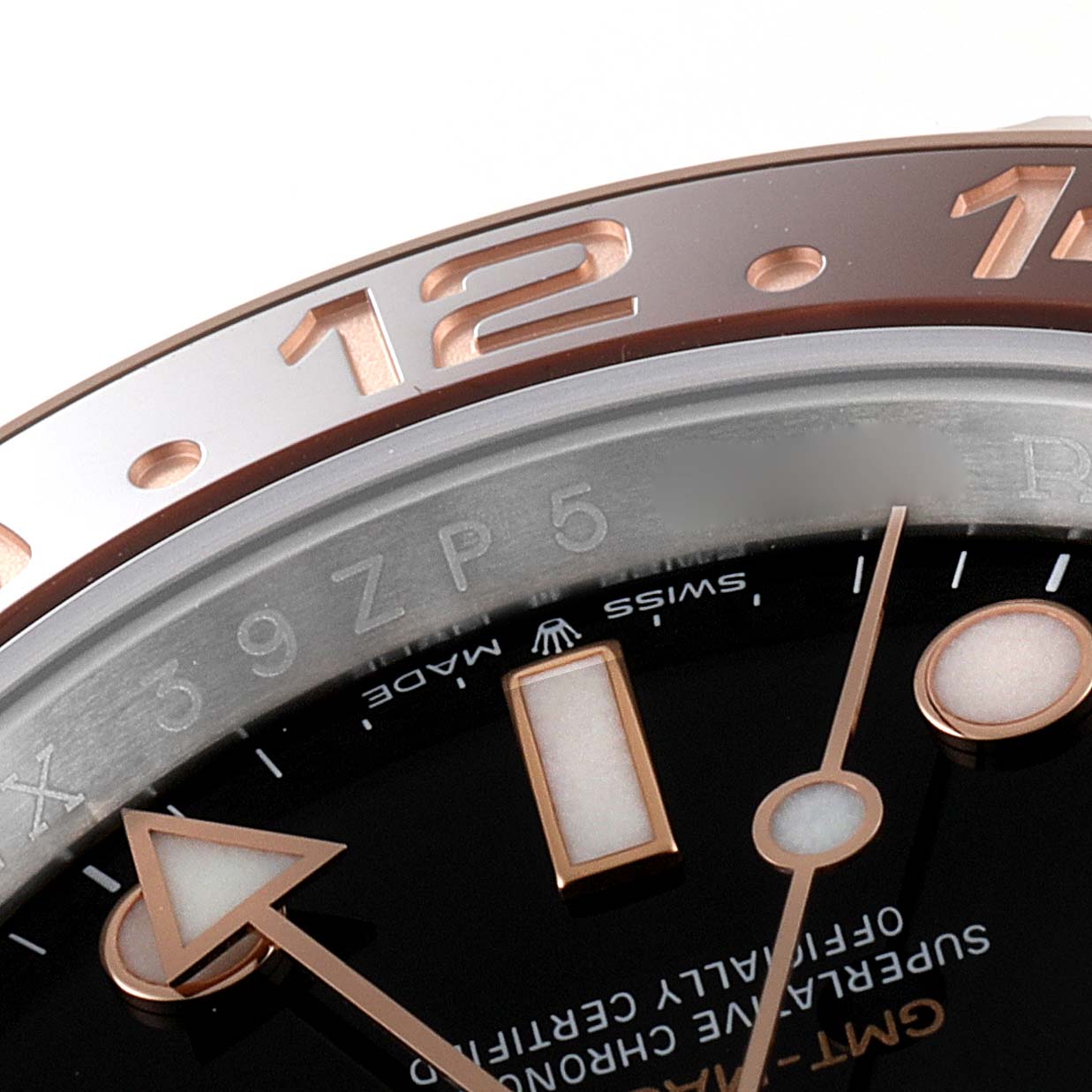 This close-up photo of a Rolex GMT-Master 126711 Men's Steel and Gold (two tone) Black Dial 126711 Men's Steel and Gold (two tone) Black Dial watch shows the bezel, part of the dial, and the hour, minute, and GMT hands.