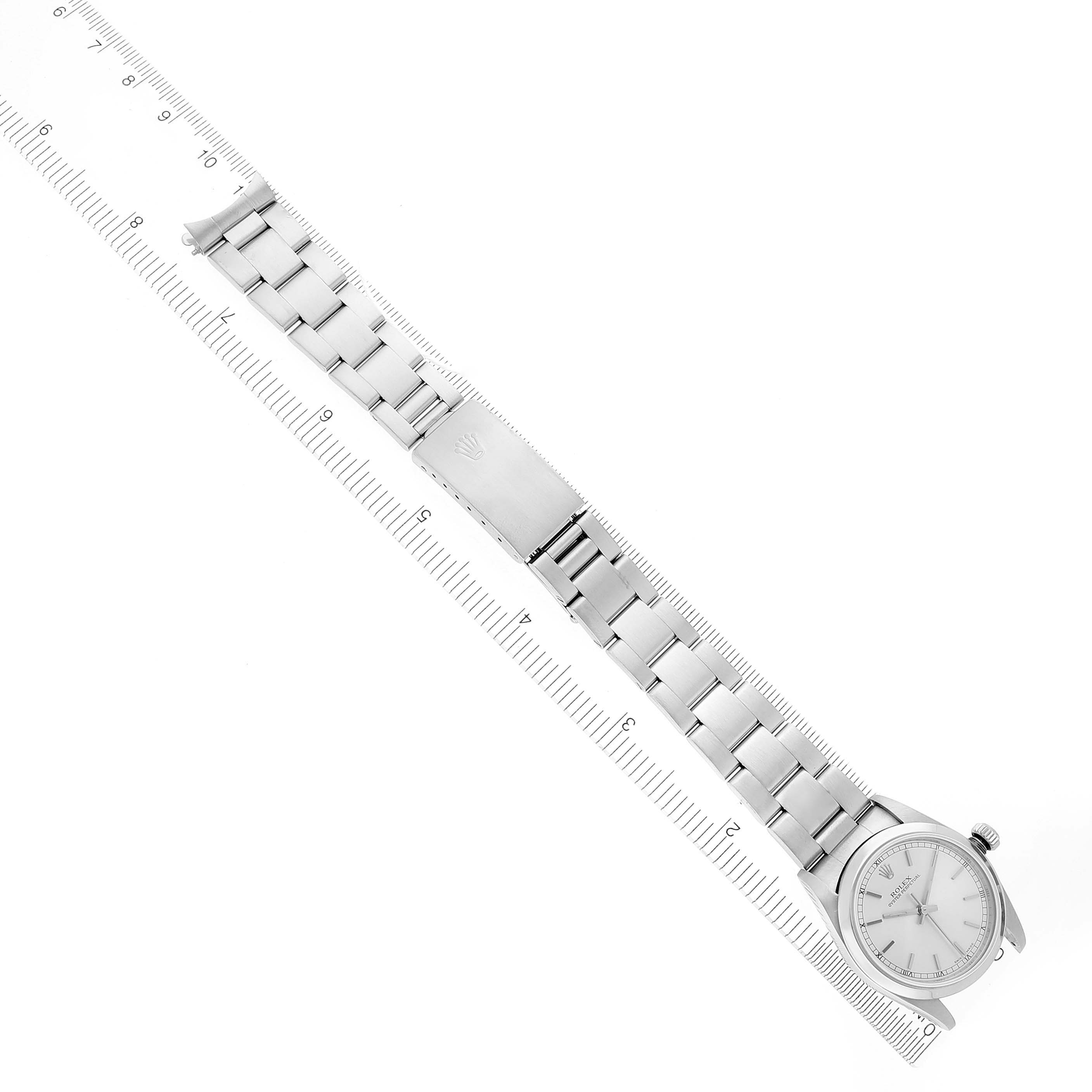The Rolex Mid-Size 77080 Women's Stainless Steel Silver Dial 77080 Women's Stainless Steel Silver Dial watch is shown at an overhead angle, displaying its face, bracelet, and clasp next to a ruler for scale.