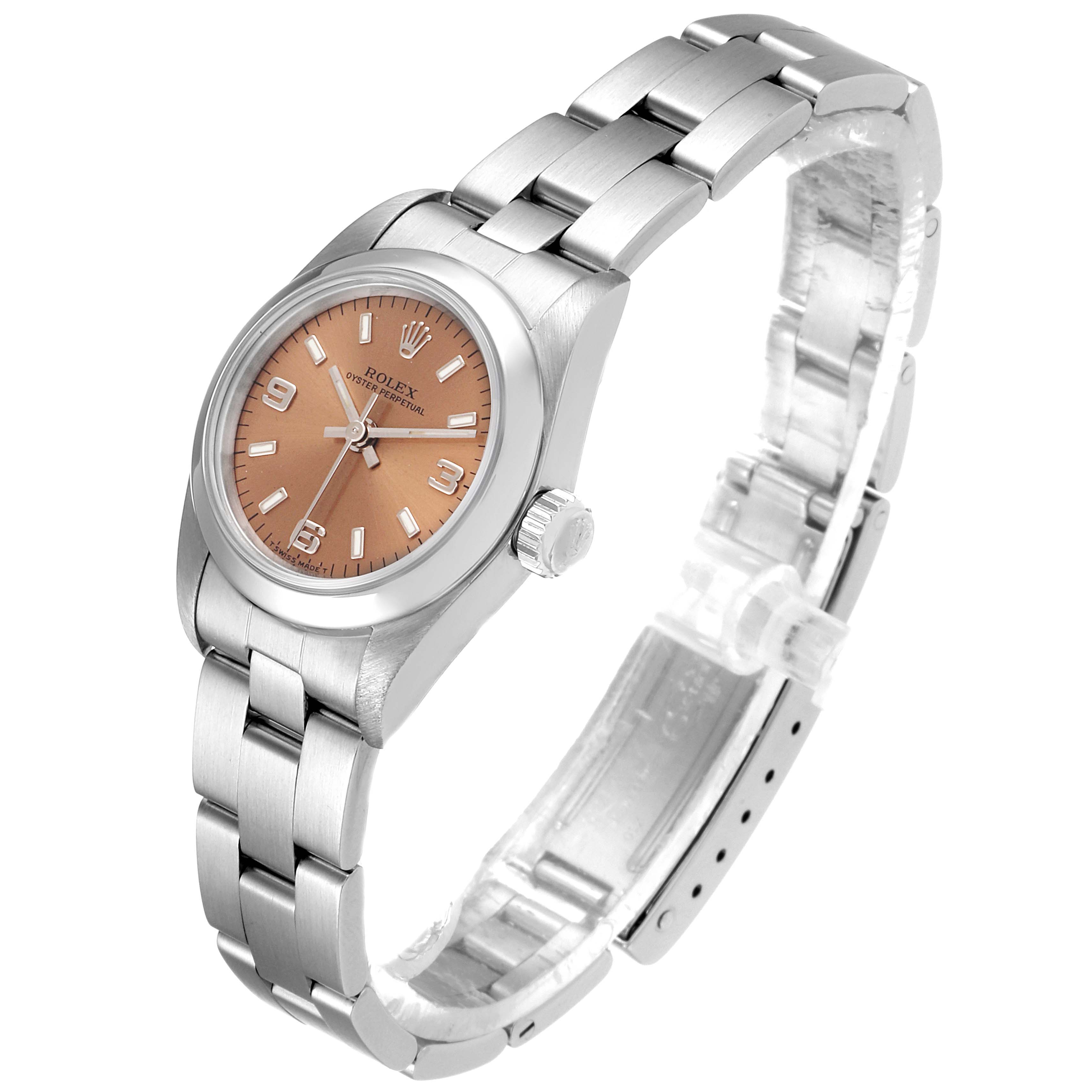 The image shows a side angle of a Rolex Oyster Perpetual 67180 Women's Stainless Steel Pink Dial 67180 Women's Stainless Steel Pink Dial watch featuring its face, crown, and stainless steel bracelet.