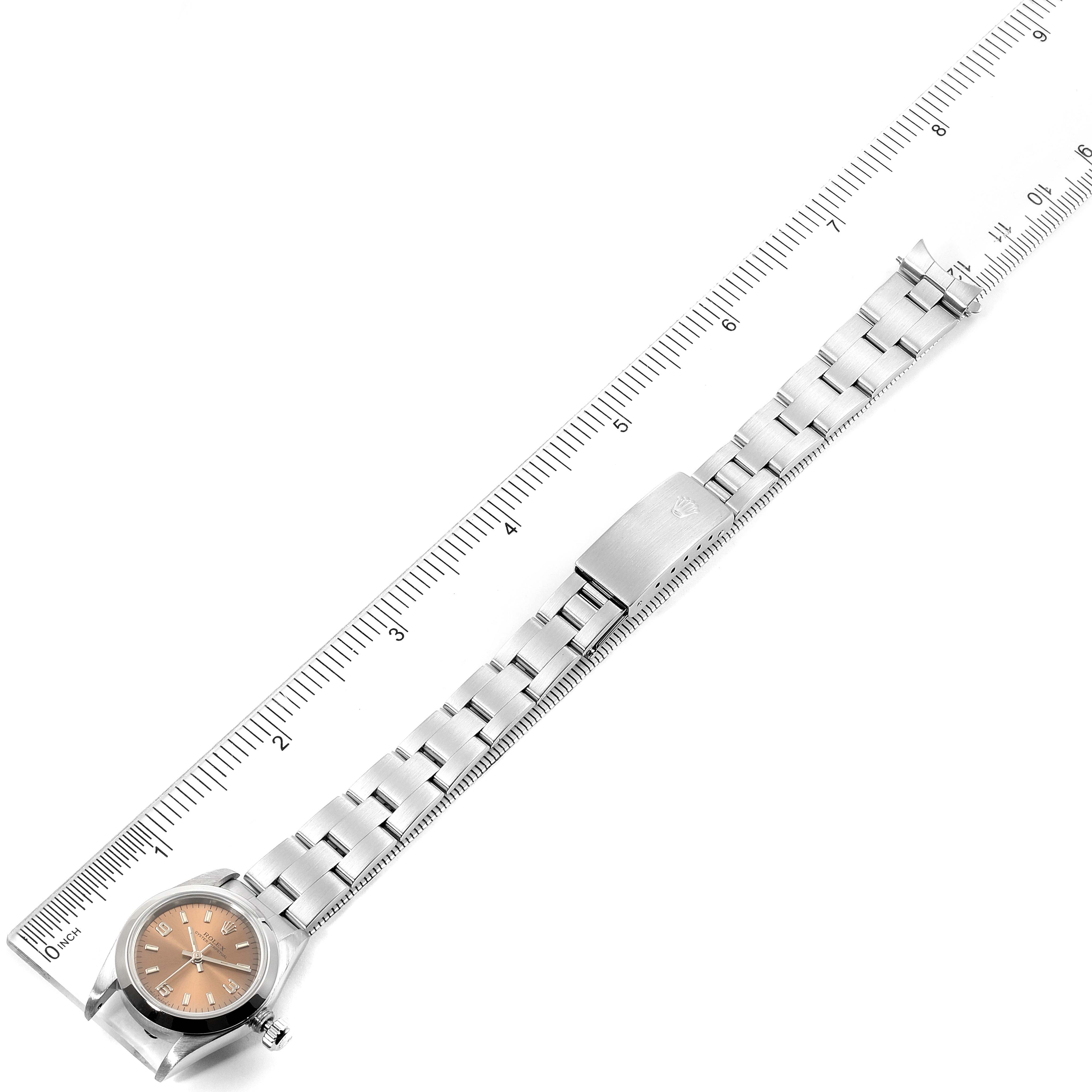 The image shows the full length of a Rolex Oyster Perpetual 67180 Women's Stainless Steel Pink Dial 67180 Women's Stainless Steel Pink Dial watch, featuring the face, bracelet, and clasp, laid next to a ruler.