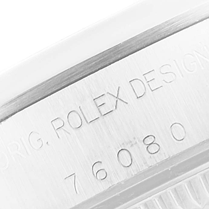 This image shows a close-up of the engraved serial number on the side of a Rolex Oyster Perpetual 76080 Women's Stainless Steel White Dial 76080 Women's Stainless Steel White Dial watch.