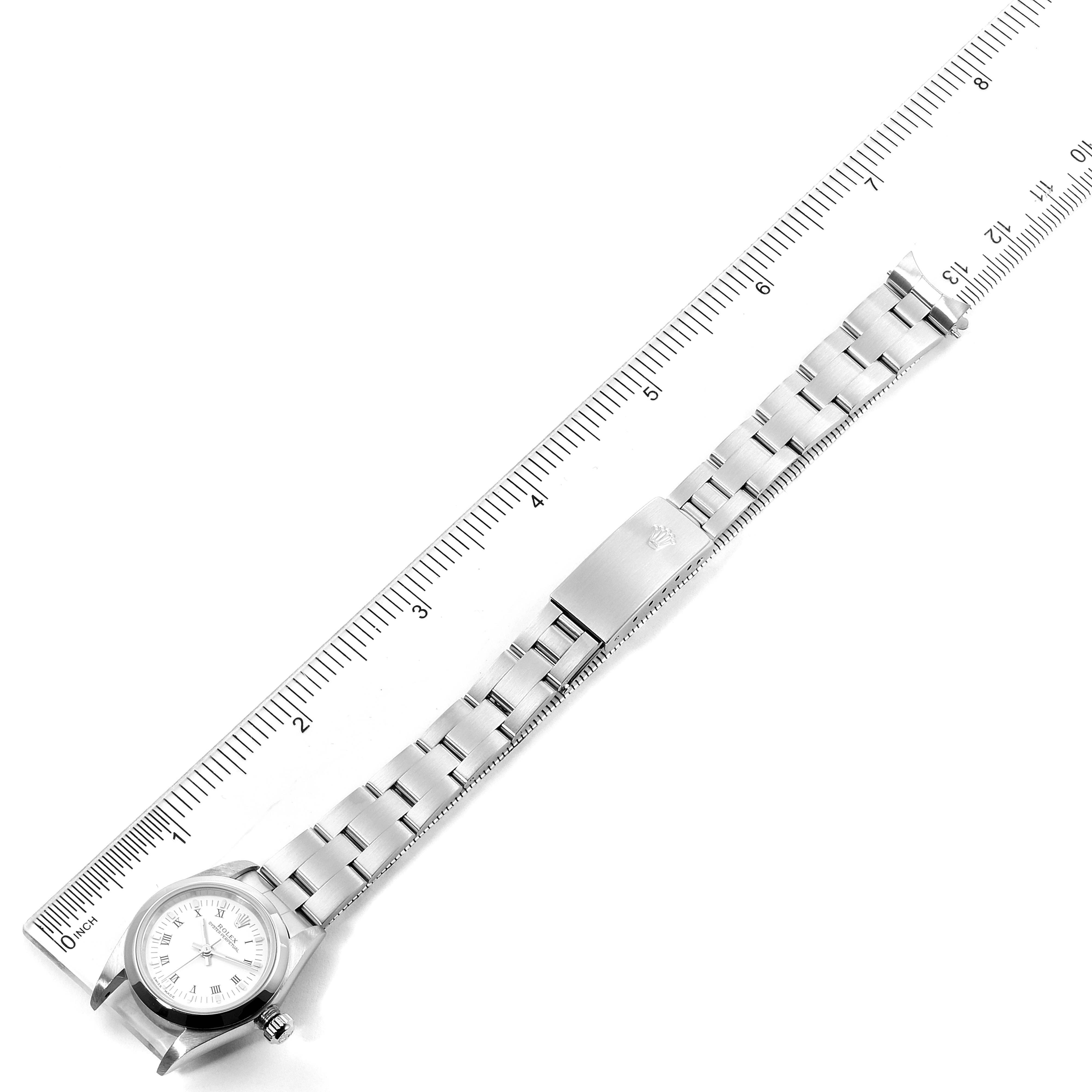 The image shows a top-down view of a Rolex Oyster Perpetual 76080 Women's Stainless Steel White Dial 76080 Women's Stainless Steel White Dial watch with its stainless steel bracelet laid against a ruler.