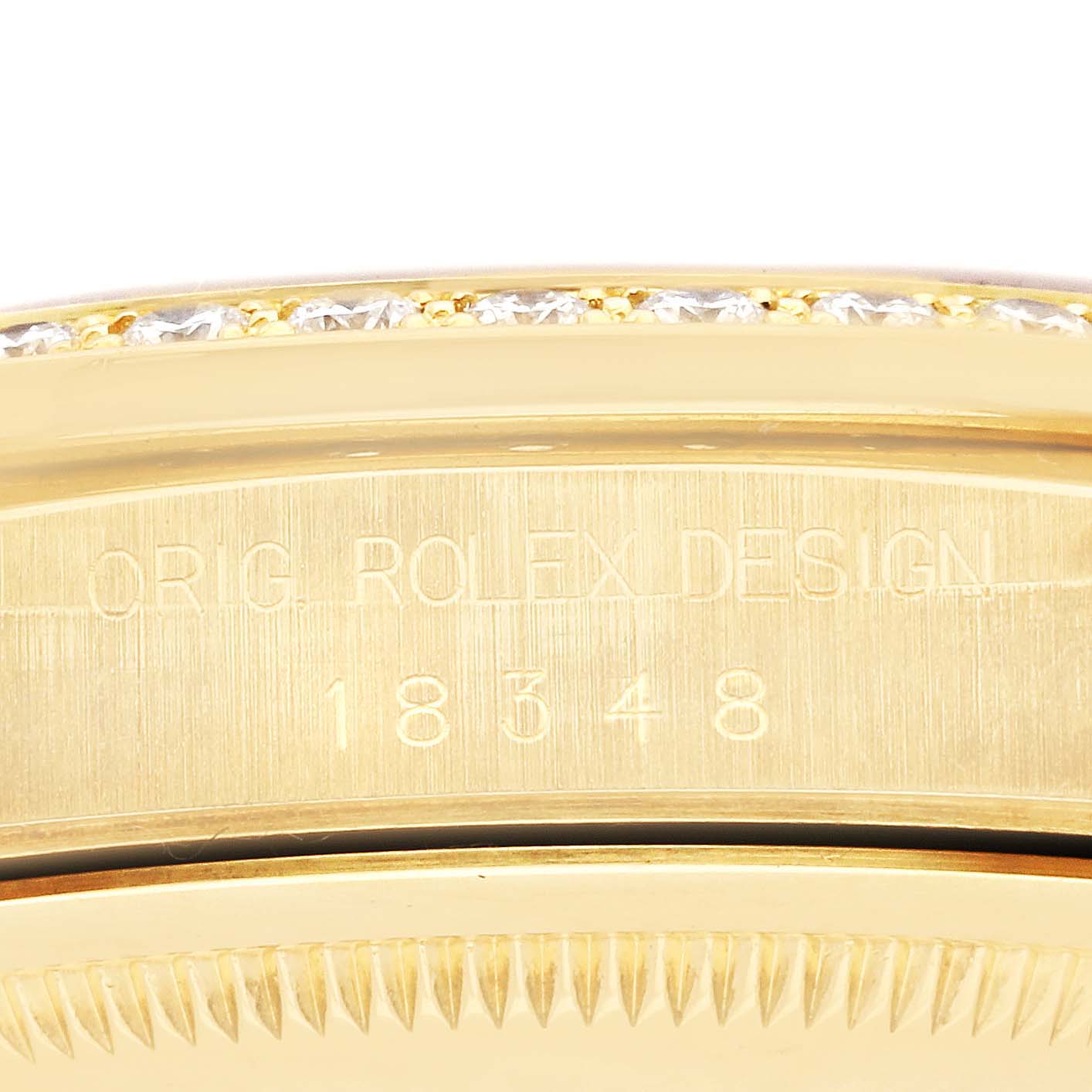 The image shows a close-up side view of the Rolex President 18348 Men
s Yellow Gold Champagne Dial 18348 Men
s Yellow Gold Champagne Dial model
s bezel and part of the case with the engraving.
