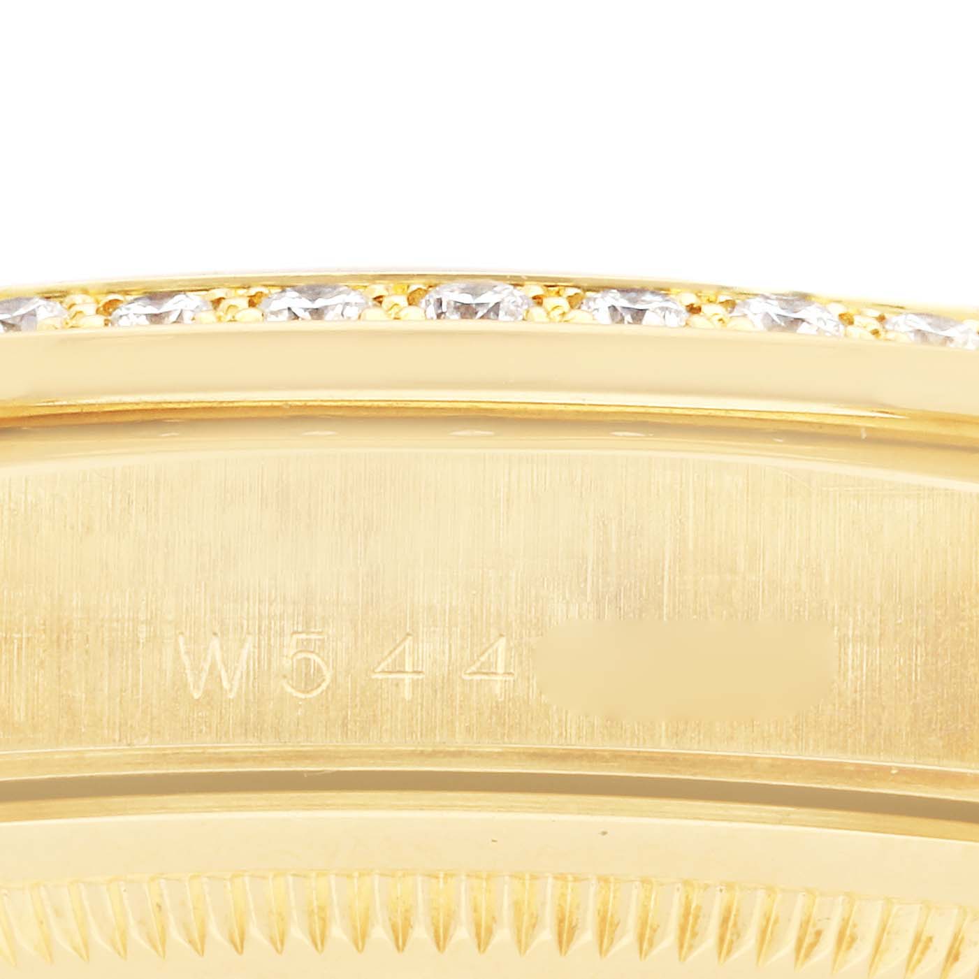 The image shows part of the bezel and engraved case side of a Rolex President 18348 Men
s Yellow Gold Champagne Dial 18348 Men
s Yellow Gold Champagne Dial model watch, with diamonds visible.