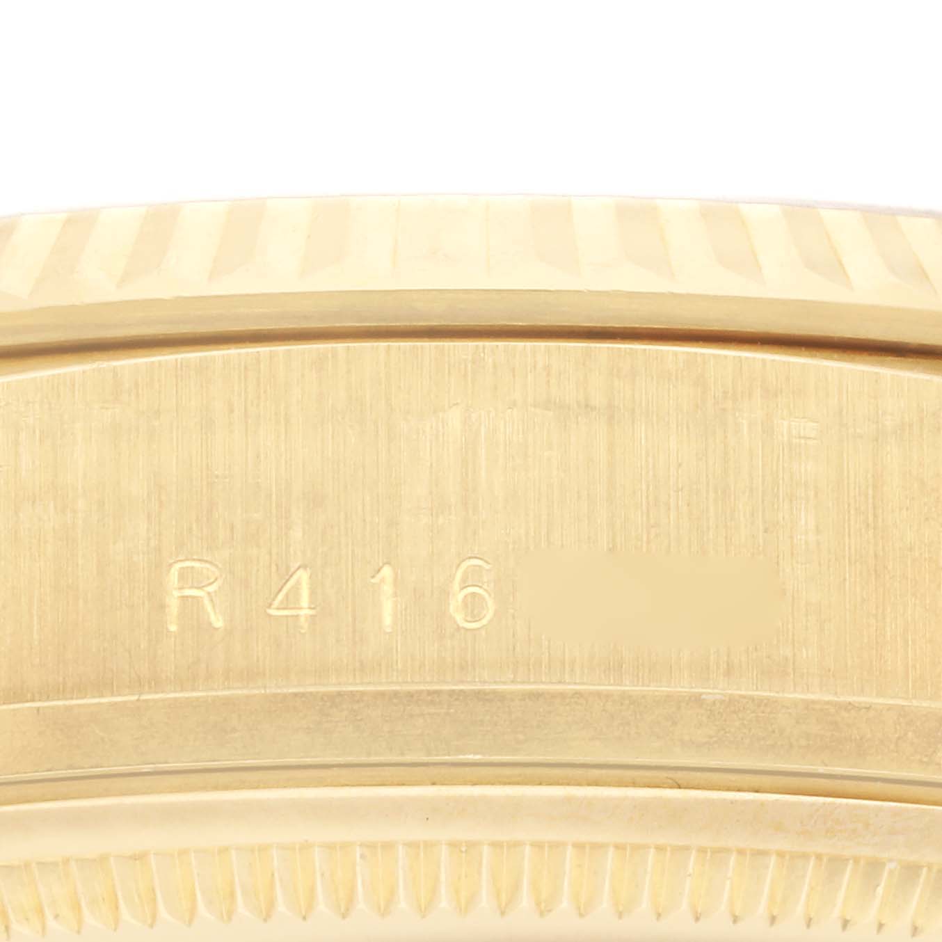 The image shows a close-up of the side of a Rolex President 18038 Men
s Yellow Gold Champagne Dial 18038 Men
s Yellow Gold Champagne Dial model, focusing on its gold fluted bezel and engravings.