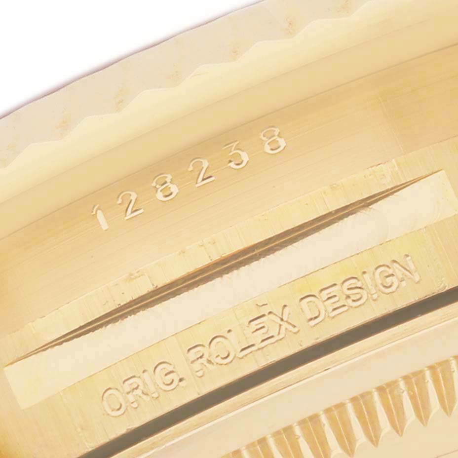 The image shows a close-up of the engraved side of a Rolex President 128238 Men's Yellow Gold Champagne Dial model watch, highlighting the serial and design numbers.