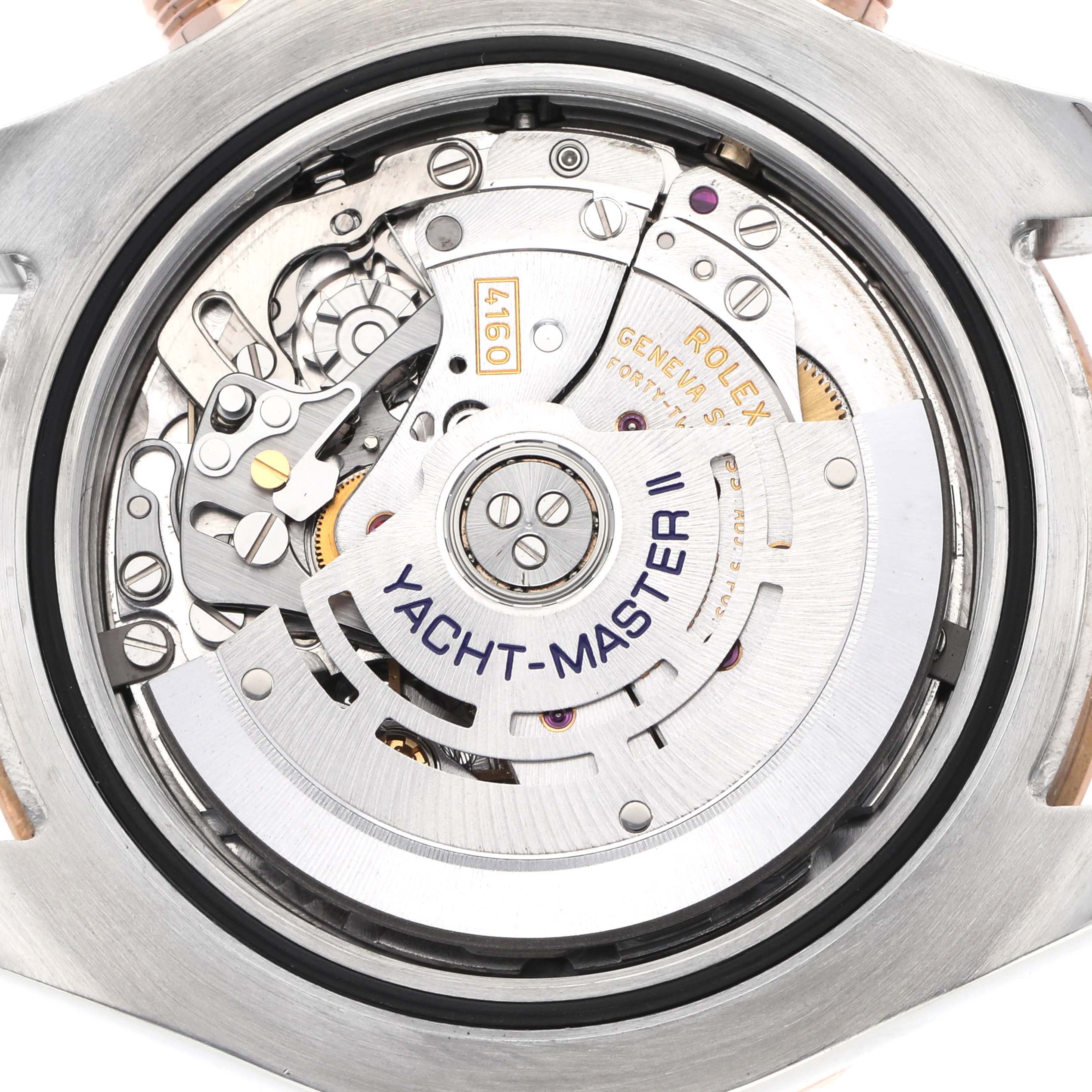 The image shows the movement from the back of a Rolex Yacht-Master 116681M Men's Steel and Gold (two tone) White Dial II, revealing gears and engravings.