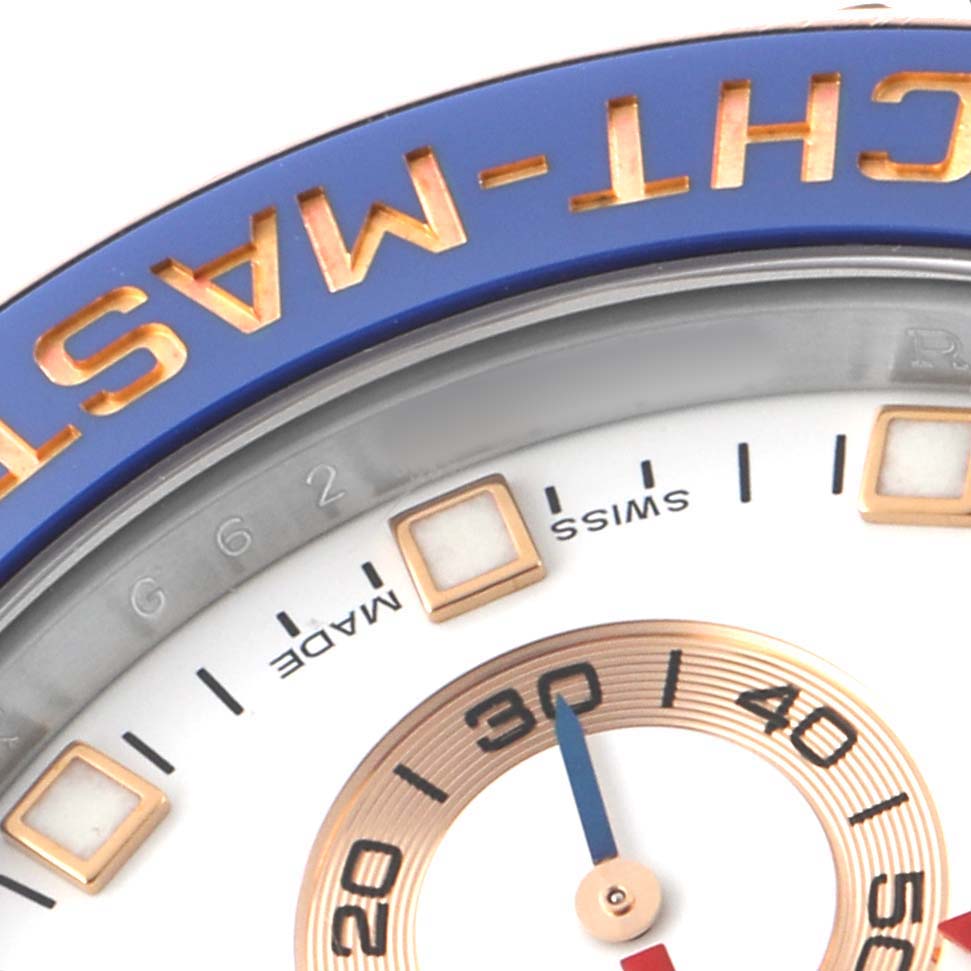 The image shows a close-up of the Rolex Yacht-Master 116681M Men's Steel and Gold (two tone) White Dial's dial and bezel, highlighting the blue and gold accents.
