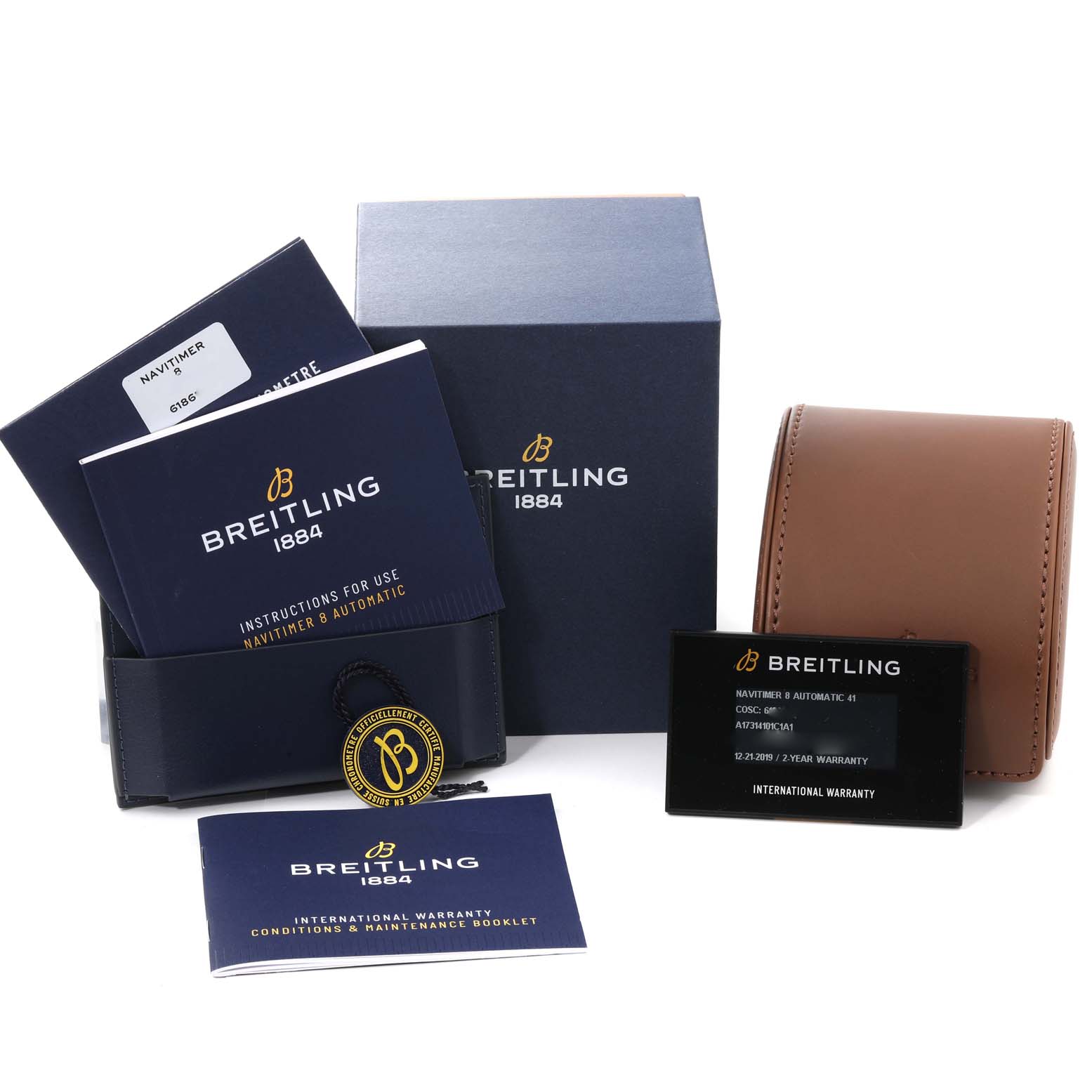 The image shows accessories for the Breitling Navitimer A17314 Men
s Stainless Steel Blue Dial A17314 Men
s Stainless Steel Blue Dial watch, including manuals, warranty cards, and a watch case, all viewed from the front.