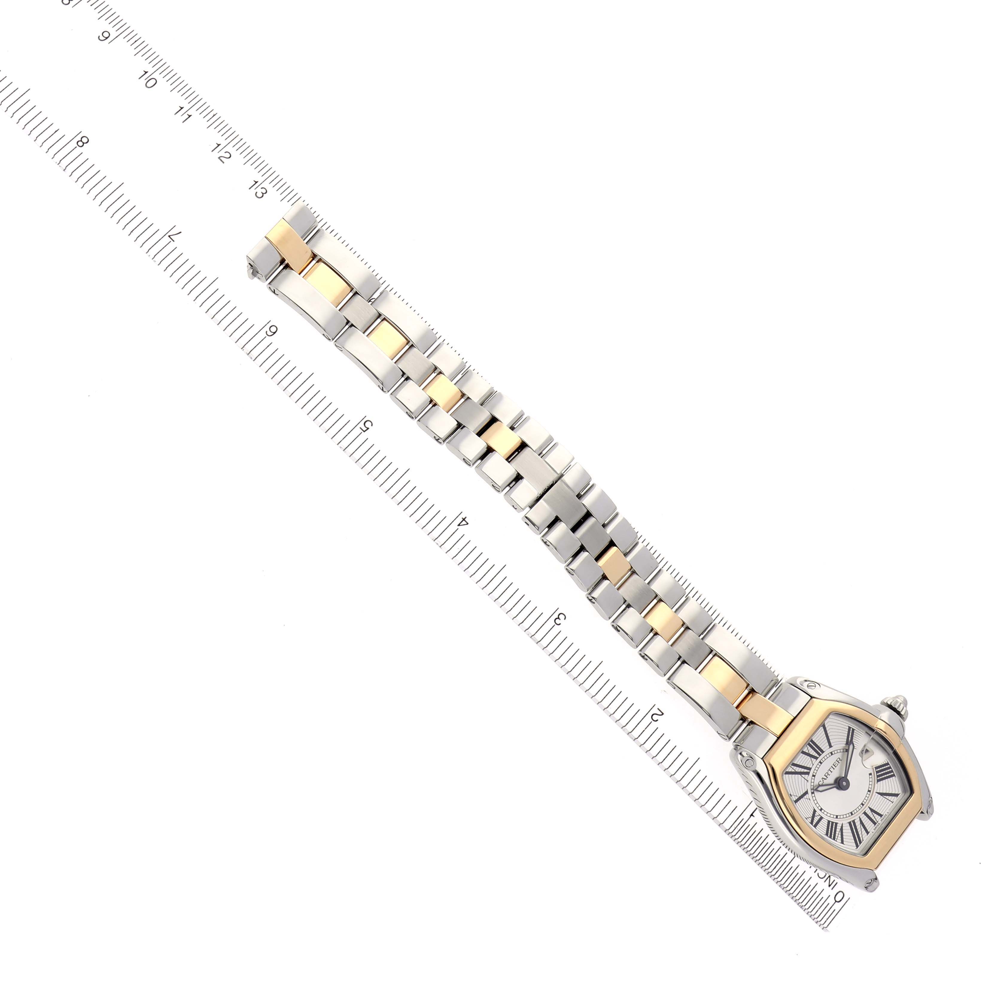 The Cartier Roadster W62026Y4 Women
s Steel and Gold (two tone) Silver Dial W62026Y4 Women
s Steel and Gold (two tone) Silver Dial watch is shown diagonally from above, displaying the face and full bracelet alongside a ruler.