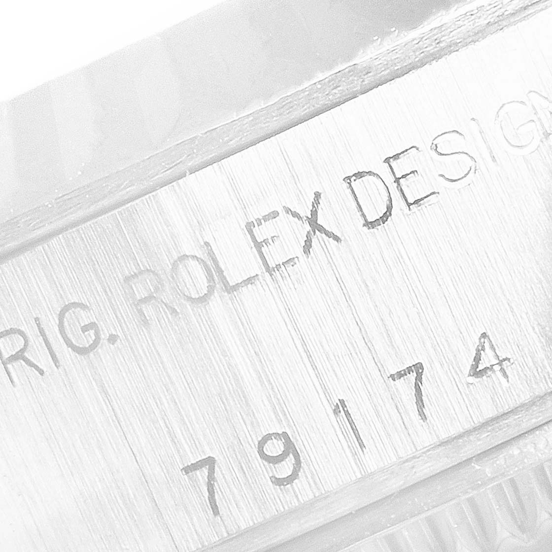 The image shows the engraved side case of a Rolex Datejust 79174 Women's Stainless Steel Blue Dial 79174 Women's Stainless Steel Blue Dial watch, displaying "ORIG. ROLEX DESIGN" and a reference number.