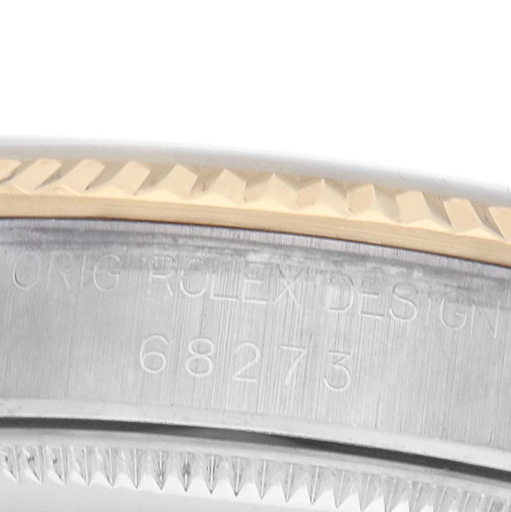 The image shows a close-up of the Rolex Datejust 68273 Women's Steel and Gold (two tone) Champagne Dial model's side and edge, highlighting the engraved design and ridged bezel.