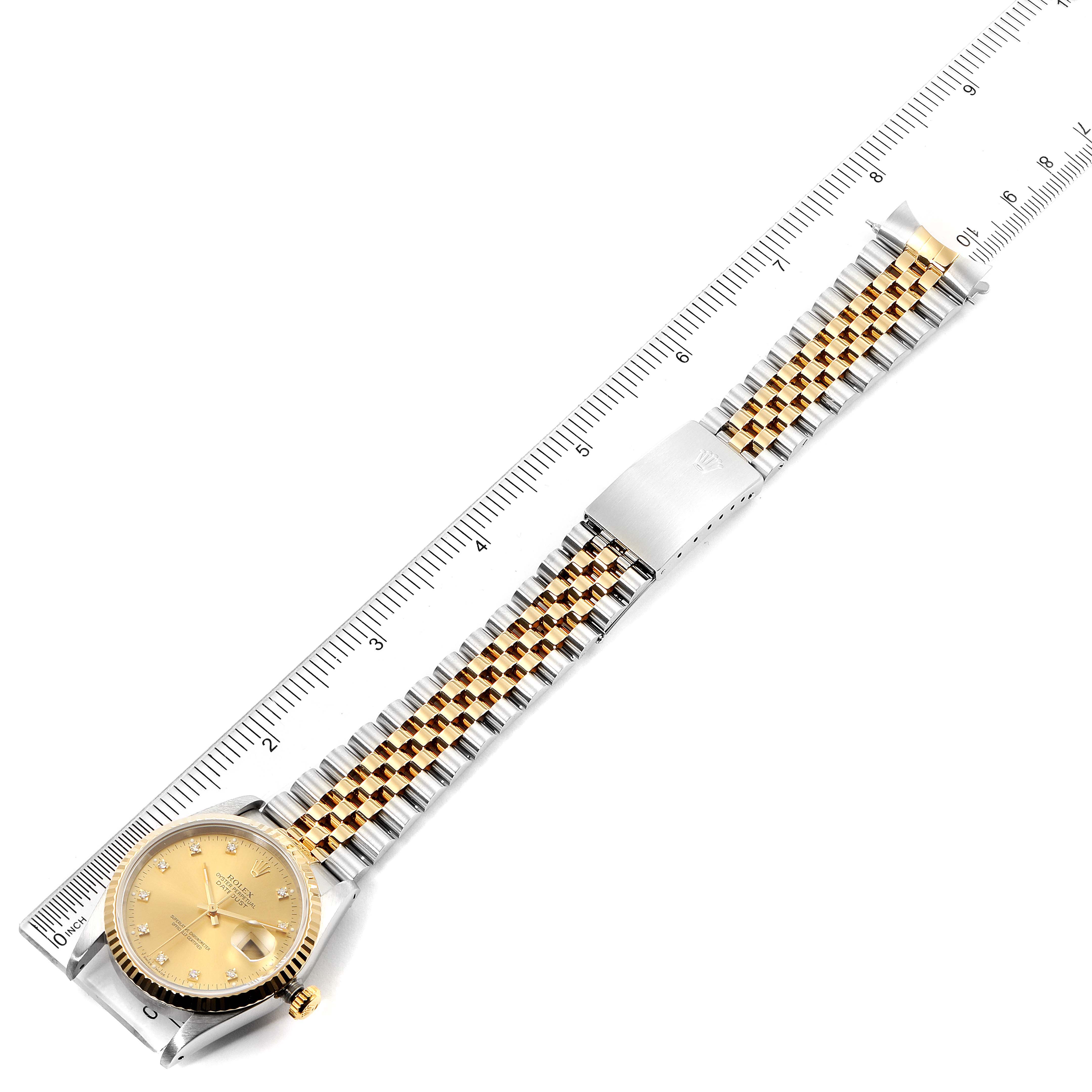 This is an overhead view of a Rolex Datejust 16233 Men's Steel and Gold (two tone) Champagne Dial 16233 Men's Steel and Gold (two tone) Champagne Dial watch, showing the face, bracelet, and clasp near a ruler for scale.