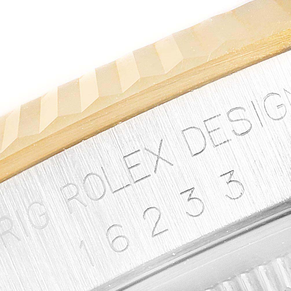 This close-up image shows the side of a Rolex Datejust 16233 Men's Steel and Gold (two tone) Champagne Dial 16233 Men's Steel and Gold (two tone) Champagne Dial watch with the model and serial number inscribed.