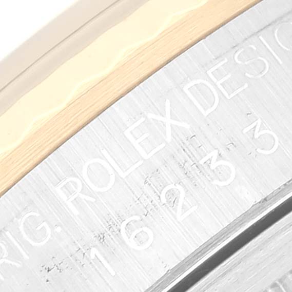 The image shows a macro view of the outer case with engraved text on a Rolex Datejust 16233G Men's Steel and Gold (two tone) Blue Dial 16233G Men's Steel and Gold (two tone) Blue Dial watch.