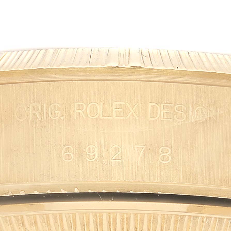 This close-up image shows the side of the case of a Rolex President 69278 Women's Yellow Gold Champagne Dial 69278 Women's Yellow Gold Champagne Dial model, highlighting the engraved design and serial number.