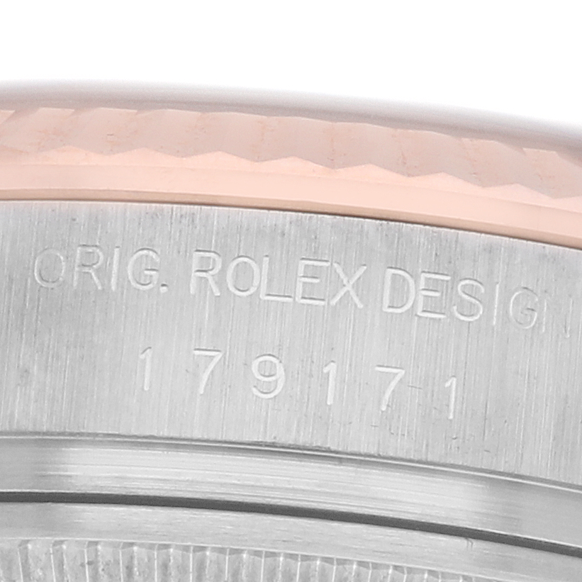 The image shows a close-up of the side of a Rolex Datejust 179171 Women's Steel and Gold (two tone) Silver Dial's bezel and engraved reference number.