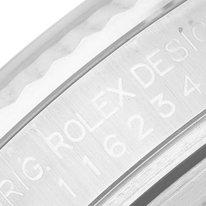 The image shows a macro view of the engraving on the side of the Rolex Datejust 116234 Men's Stainless Steel Silver Dial 116234 Men's Stainless Steel Silver Dial watch bezel.
