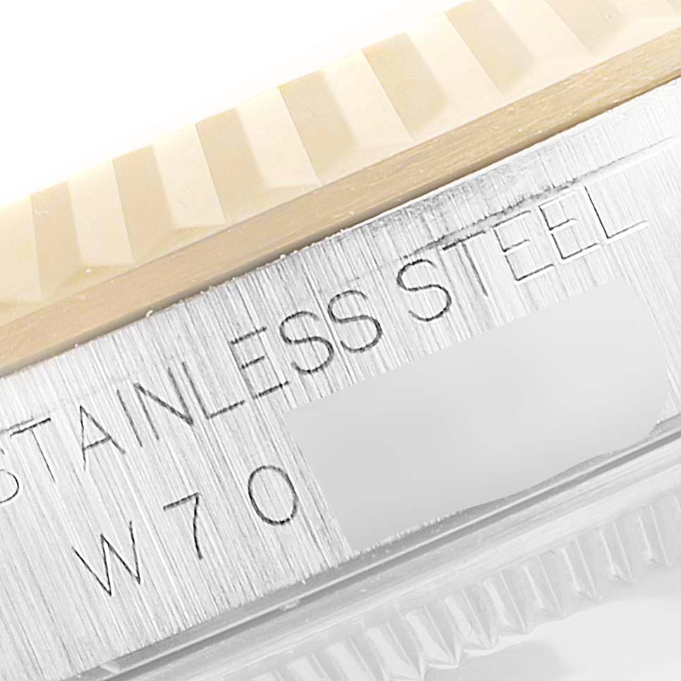 This close-up image of a Rolex Datejust 16233 Men's Steel and Gold (two tone) Black Dial 16233 Men's Steel and Gold (two tone) Black Dial shows part of the fluted bezel and "STAINLESS STEEL" engraving on the case.