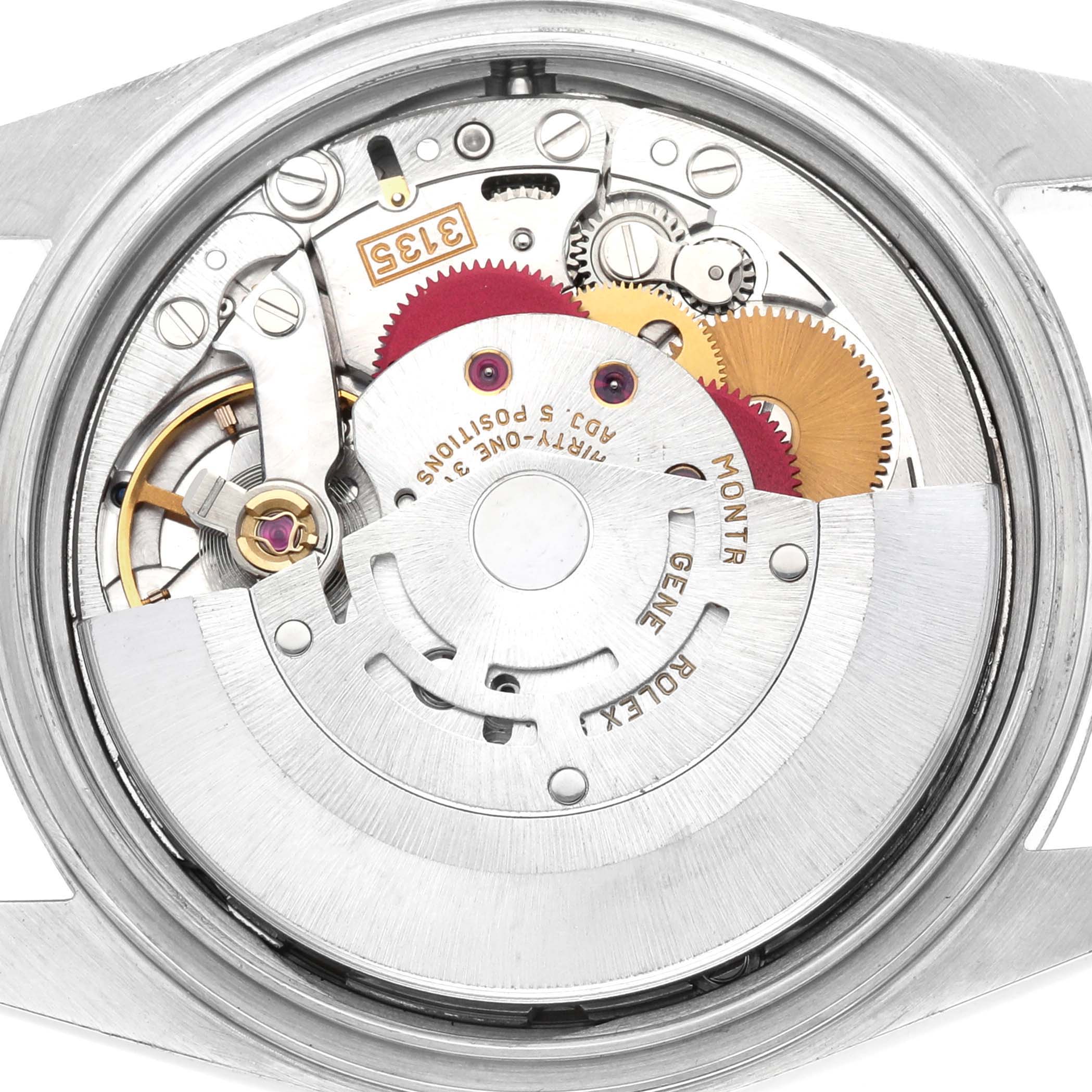 The image shows the movement of a Rolex Datejust 16233 Men's Steel and Gold (two tone) White Dial watch from a back angle, highlighting gears and intricate internal components.